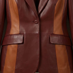 Single‑button front and flap pockets on women’s burgundy two‑tone leather blazer