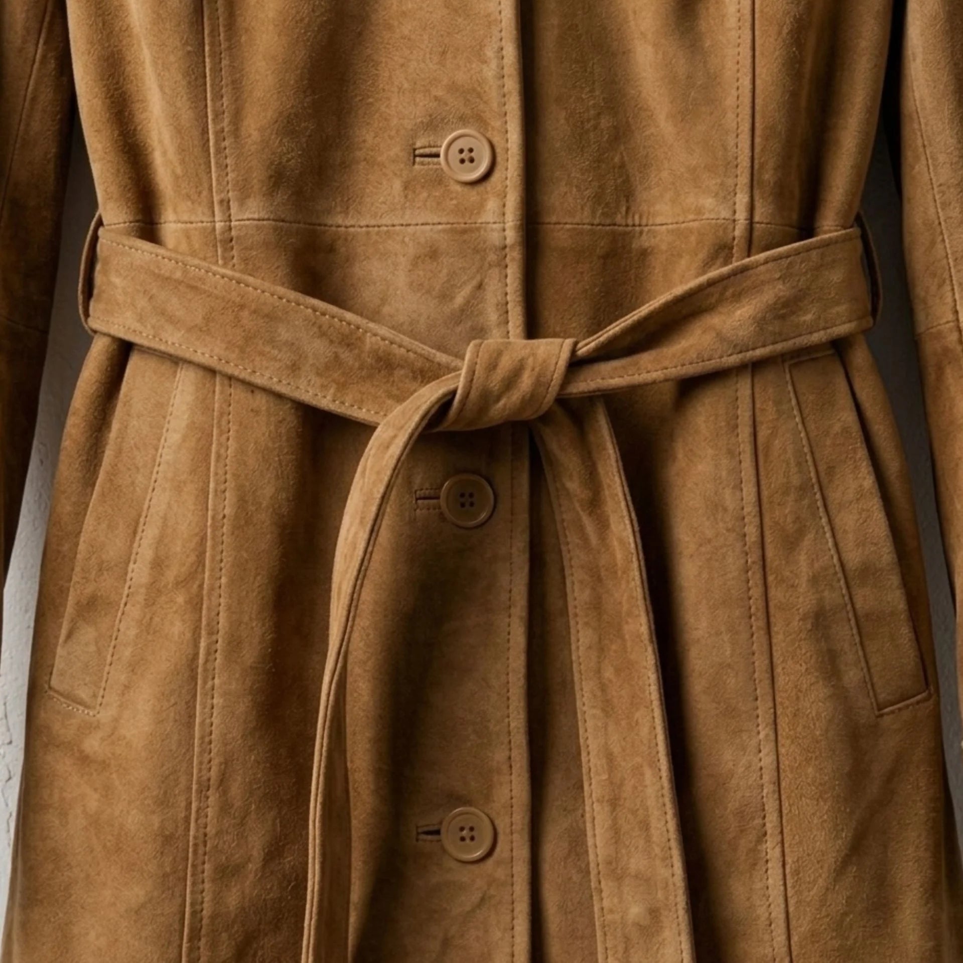 Belted waist and button front detail on women’s brown suede coat