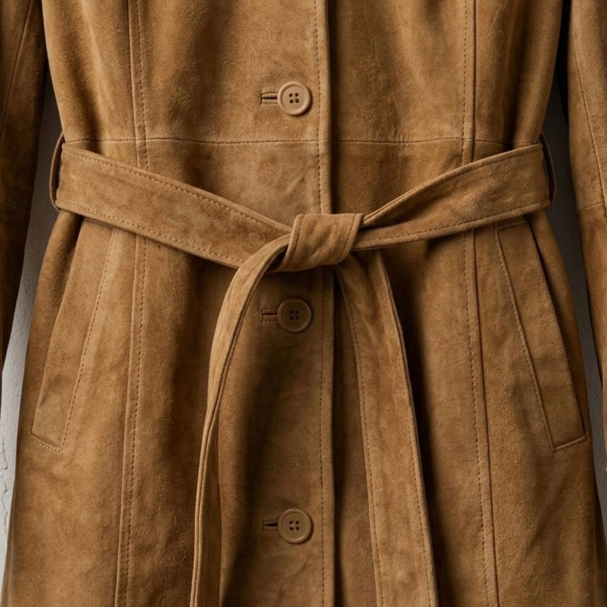 Belted waist and button front detail on women’s brown suede coat