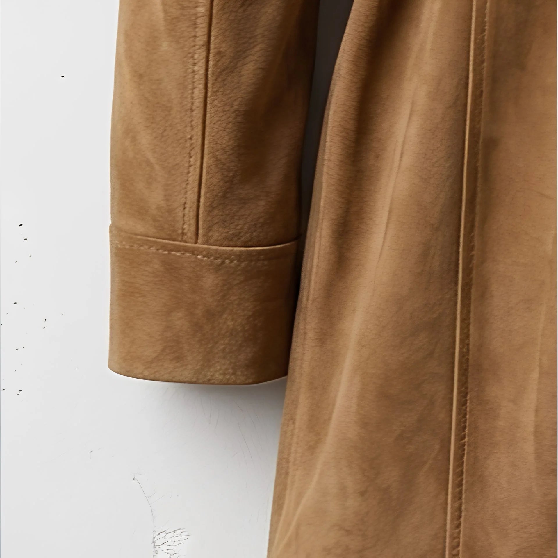 Sleeve cuff and suede texture detail on women’s camel coat