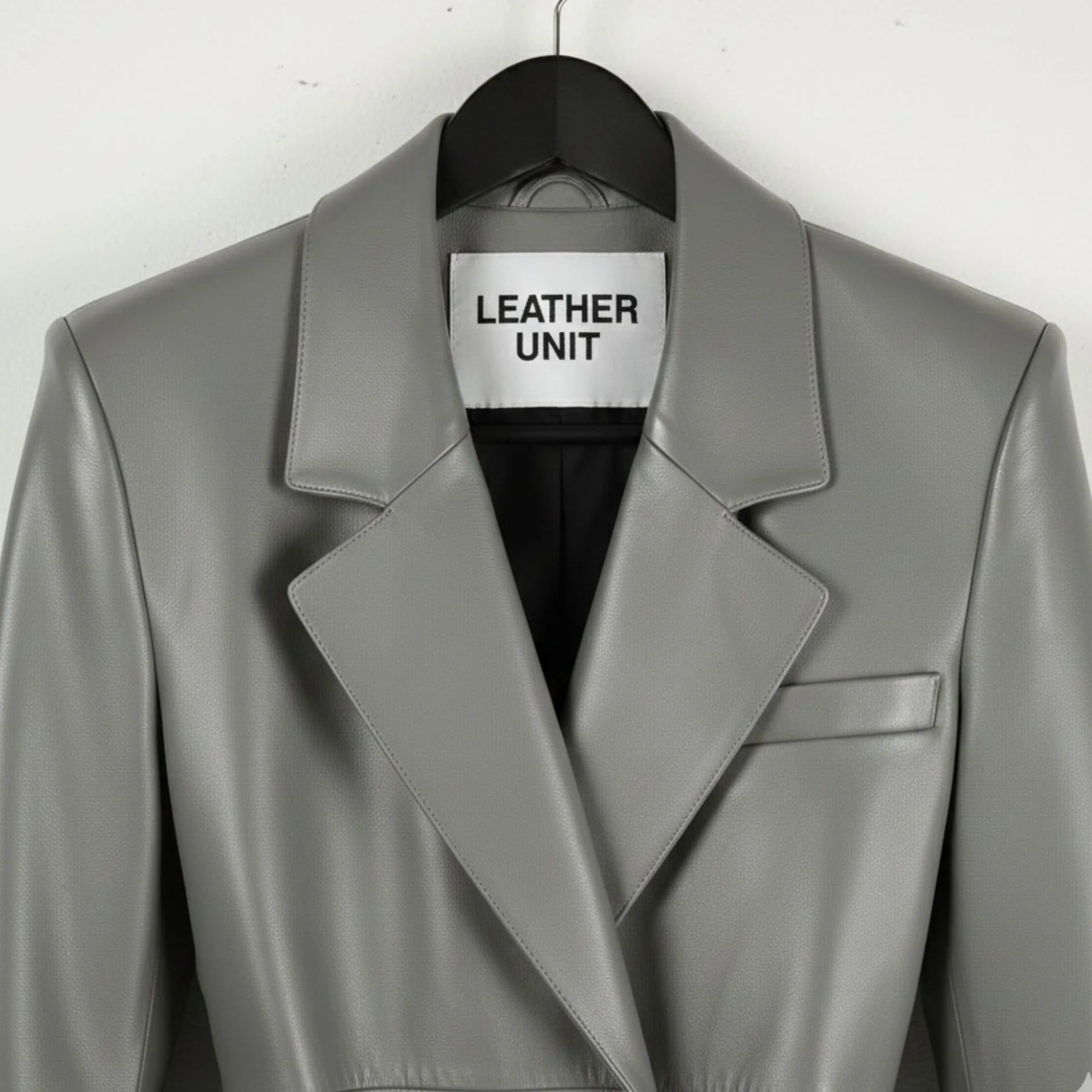 Close up of lapel collar and Leather Unit label on grey leather trench