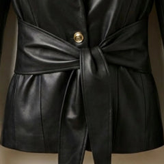 Gold button and tie waist belt detail on women’s black leather blazer