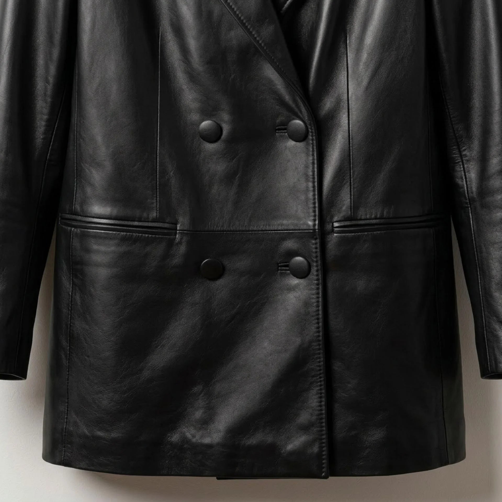 Double breasted button front and welt pockets on women’s black leather blazer