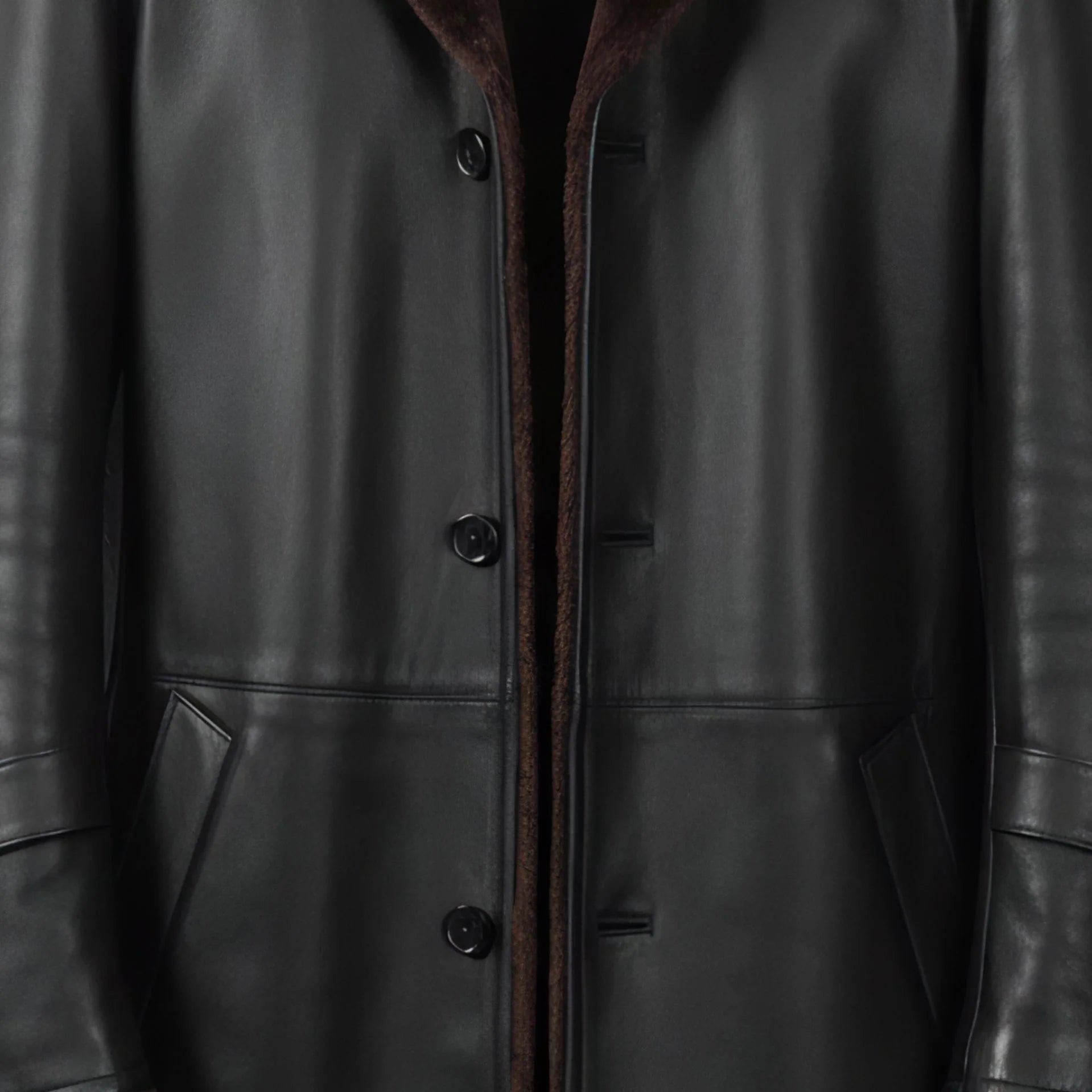 Button front and welt pockets on men’s black 3/4 length shearling coat