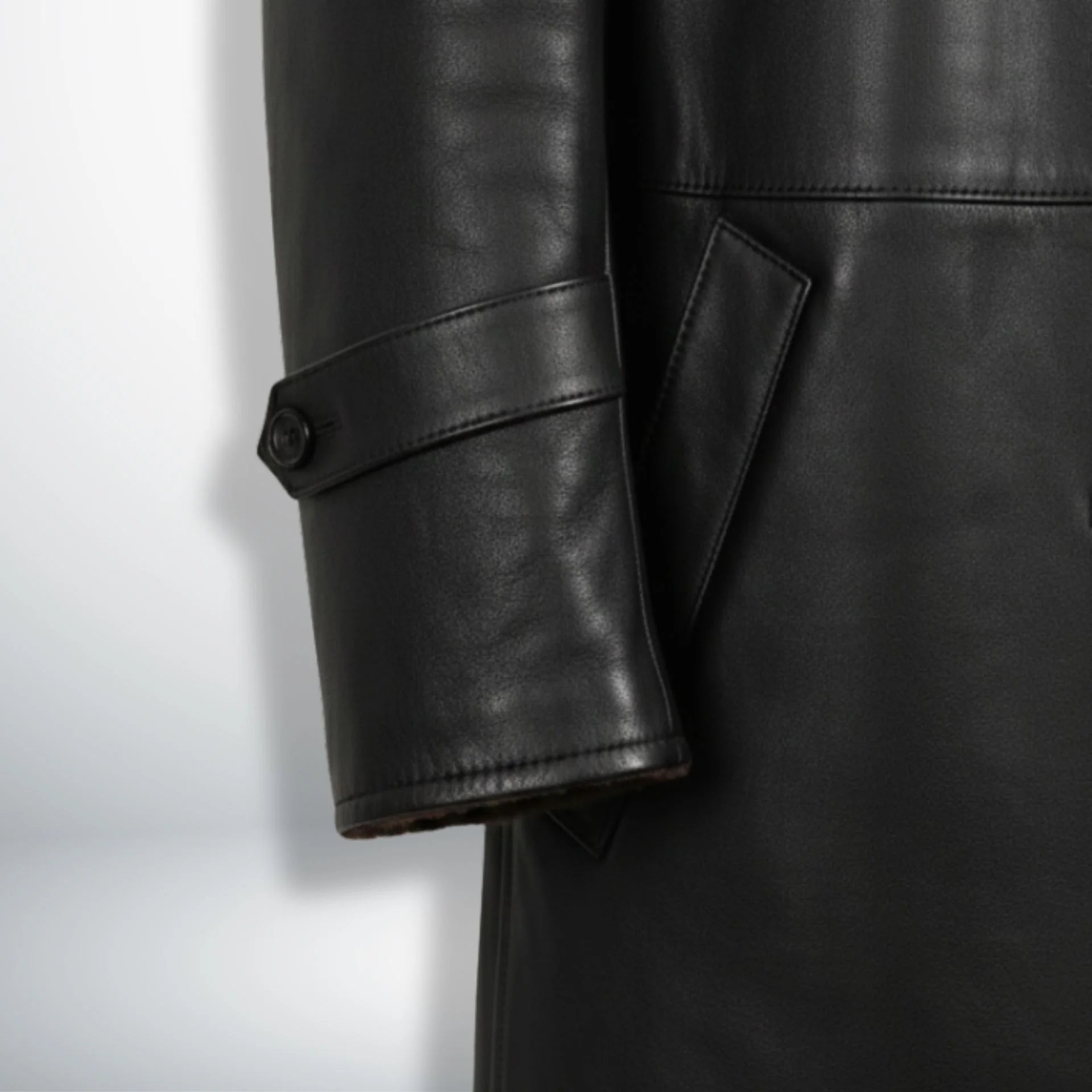 Sleeve strap and cuff detail on men’s black shearling leather coat