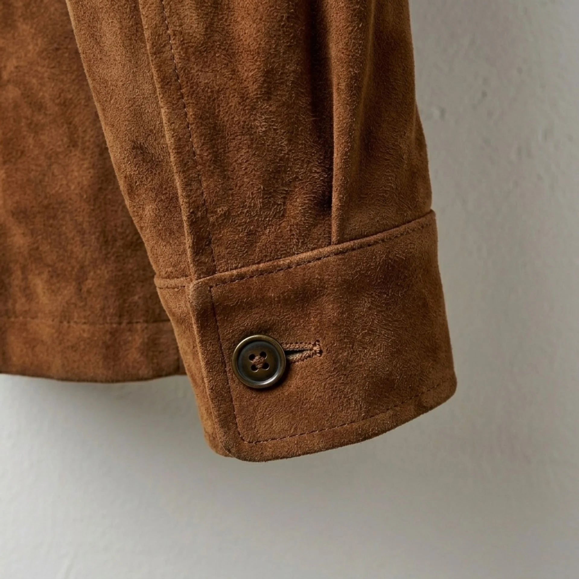 Button cuff detail on men's brown suede leather coat