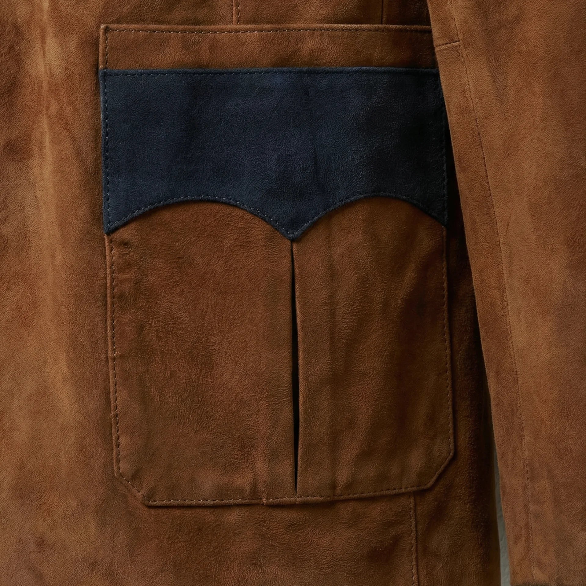 Close view of western style patch pocket with navy suede trim on blazer