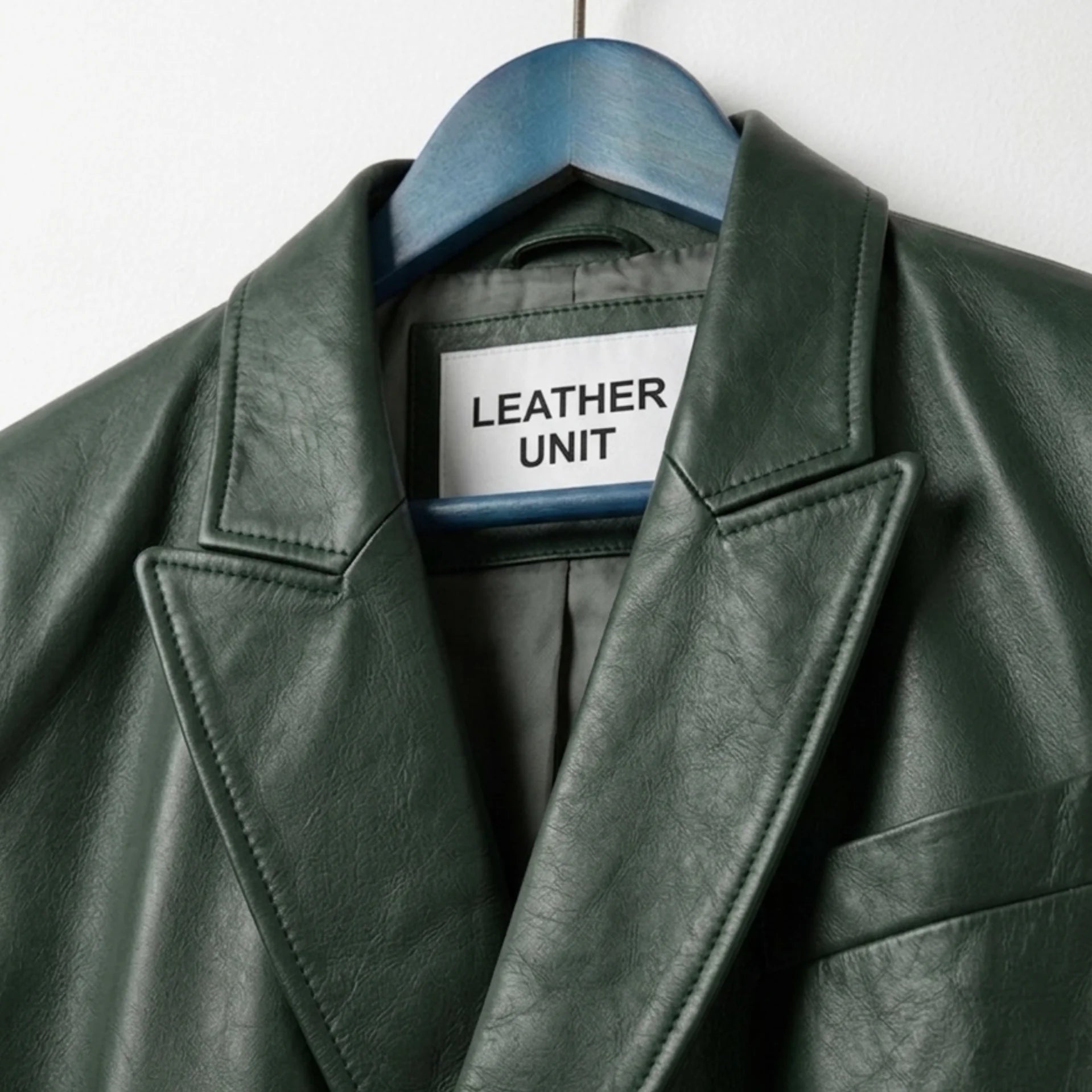 Close up of lapel collar and Leather Unit label on green leather blazer