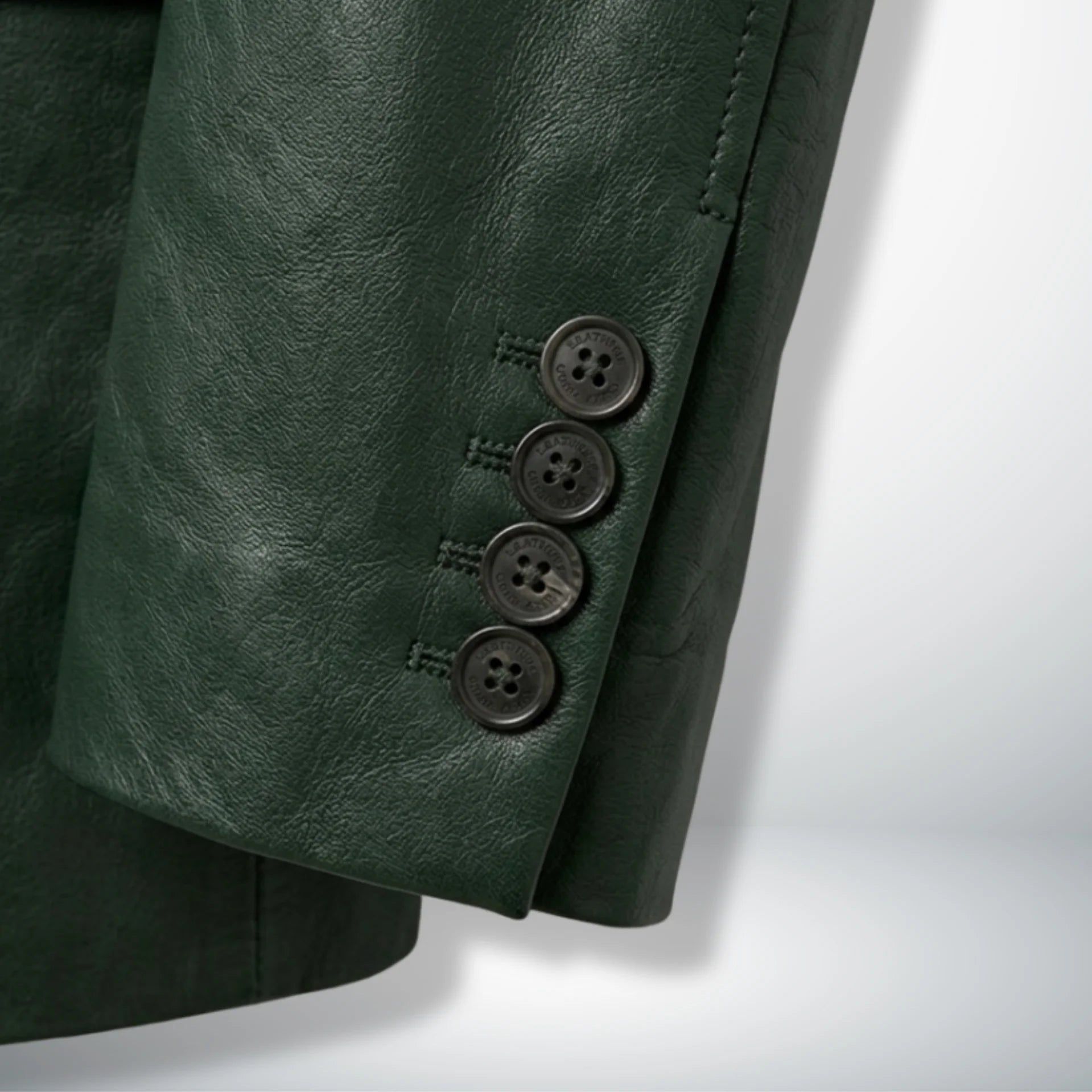 Detail of sleeve cuff buttons on men’s dark green leather blazer