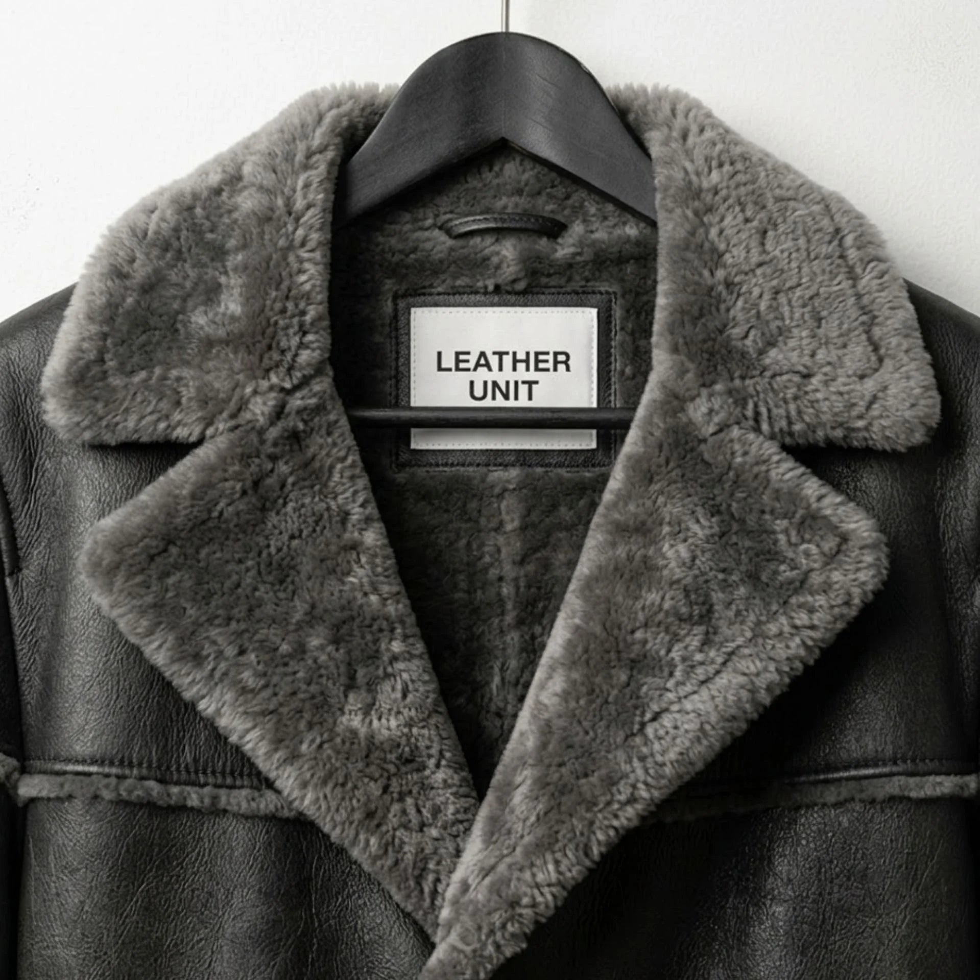 Close up of grey shearling collar and Leather Unit label on men’s coat