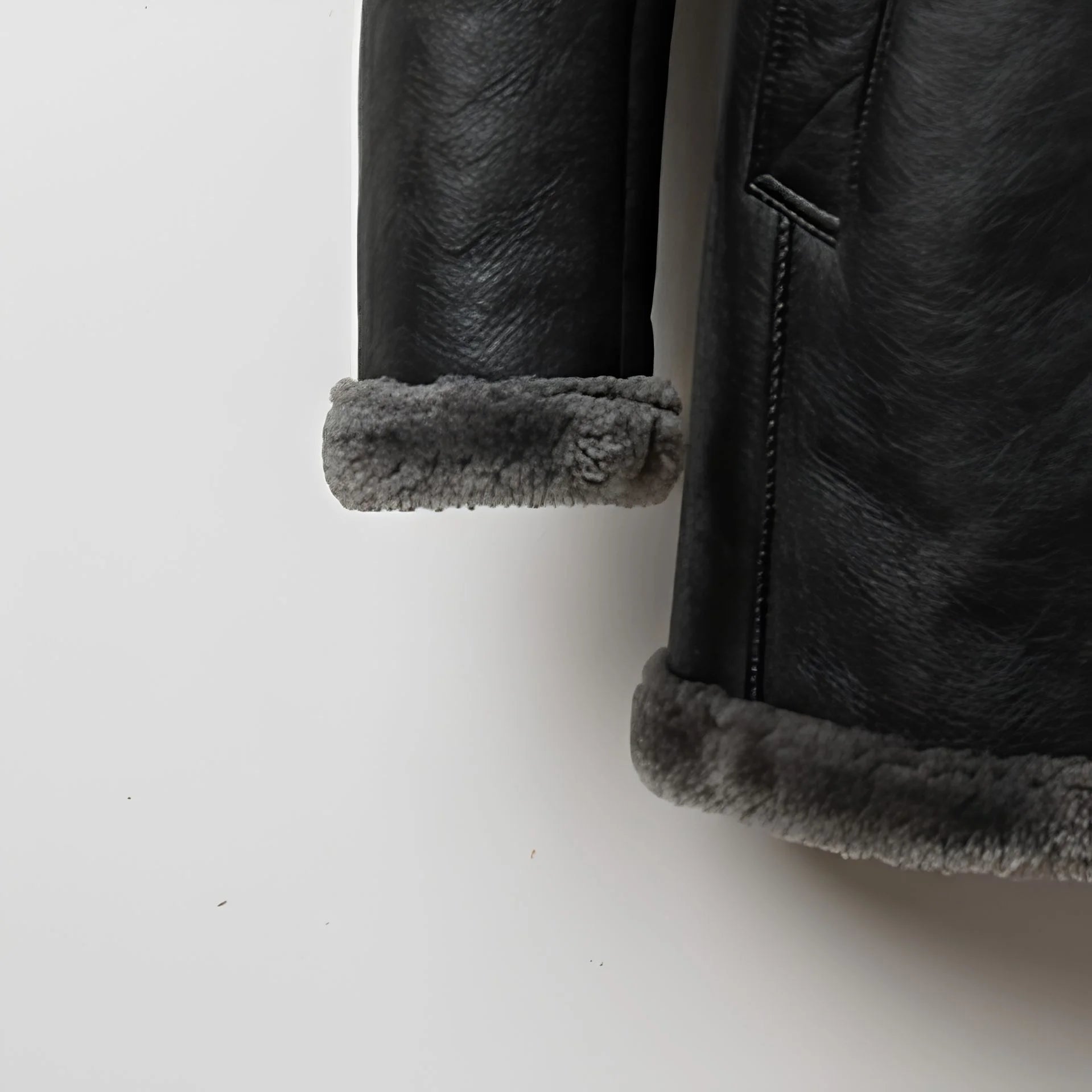 Turn‑back shearling cuff detail on men’s grey sheepskin parka coat
