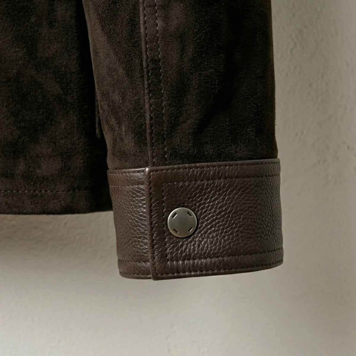 Leather cuff with snap-button detail on men's brown suede trucker jacket