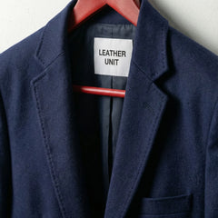 Close up of notch lapels and Leather Unit label on navy blazer