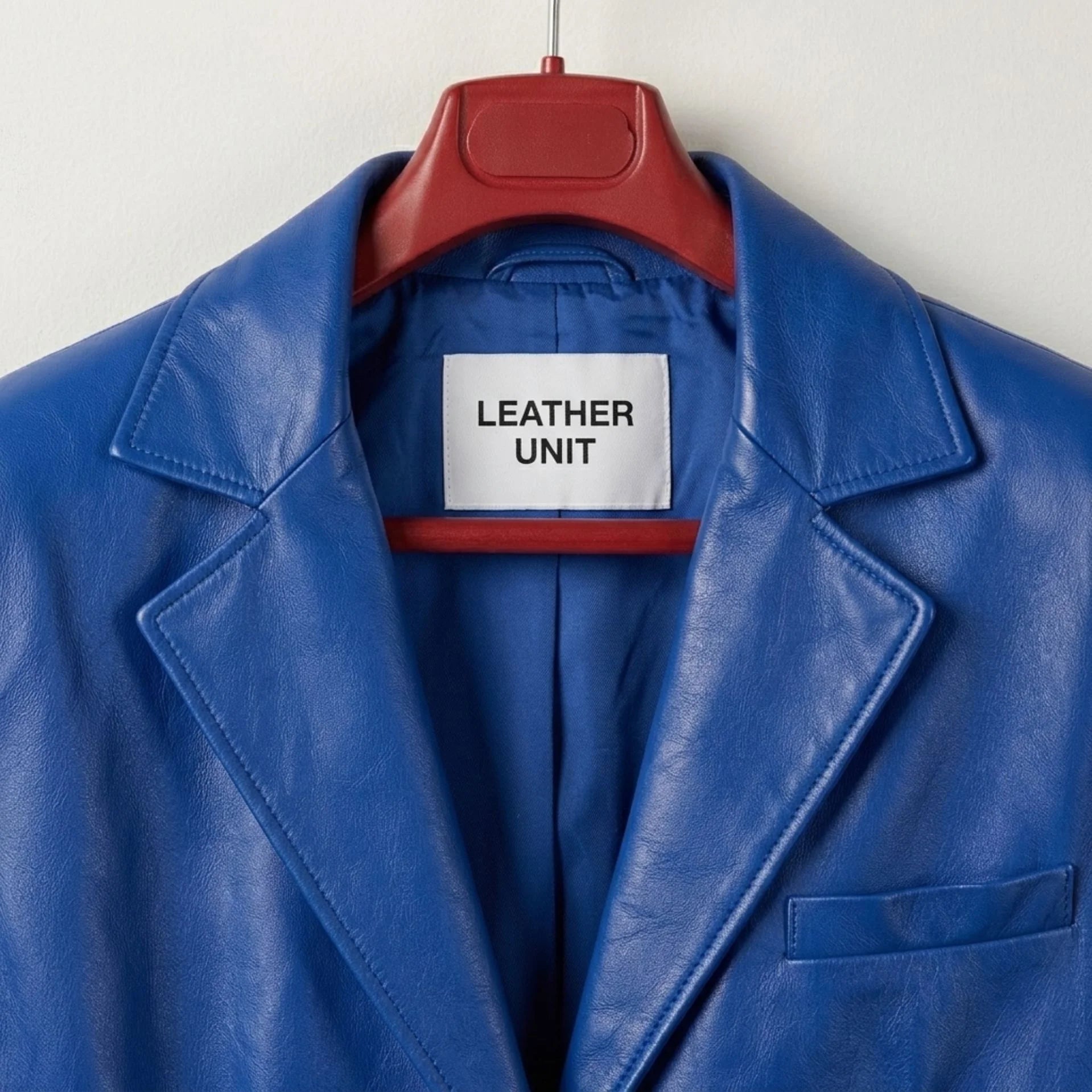 Close up of notched lapels and Leather Unit label on blue leather blazer