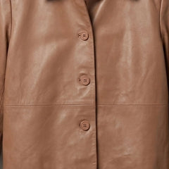 Close-up of button front detail on a women's tan cropped leather shirt jacket