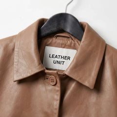 Close-up of the collar on a women's tan cropped leather shirt jacket