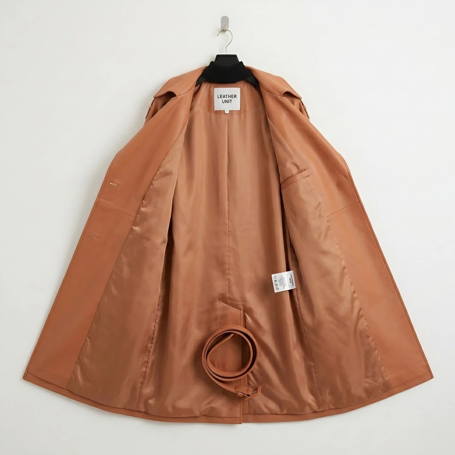 Inside lining of tan leather trench coat showing belt and inner panels