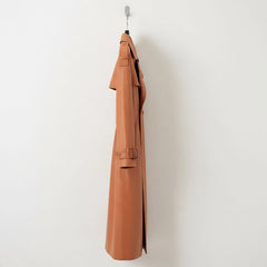 Side profile of long tan leather trench coat with waist belt