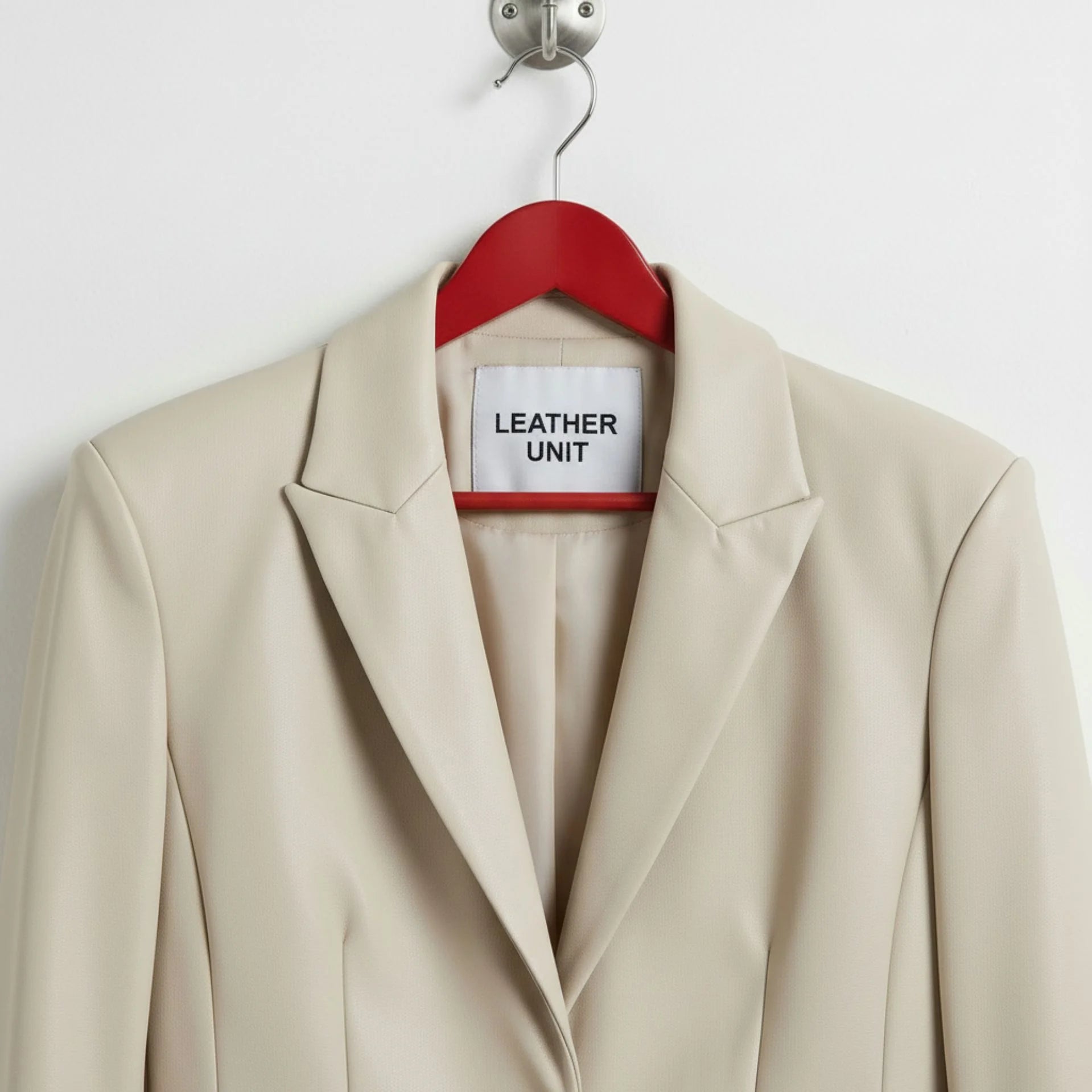 Close up of notched lapels and Leather Unit label on white blazer