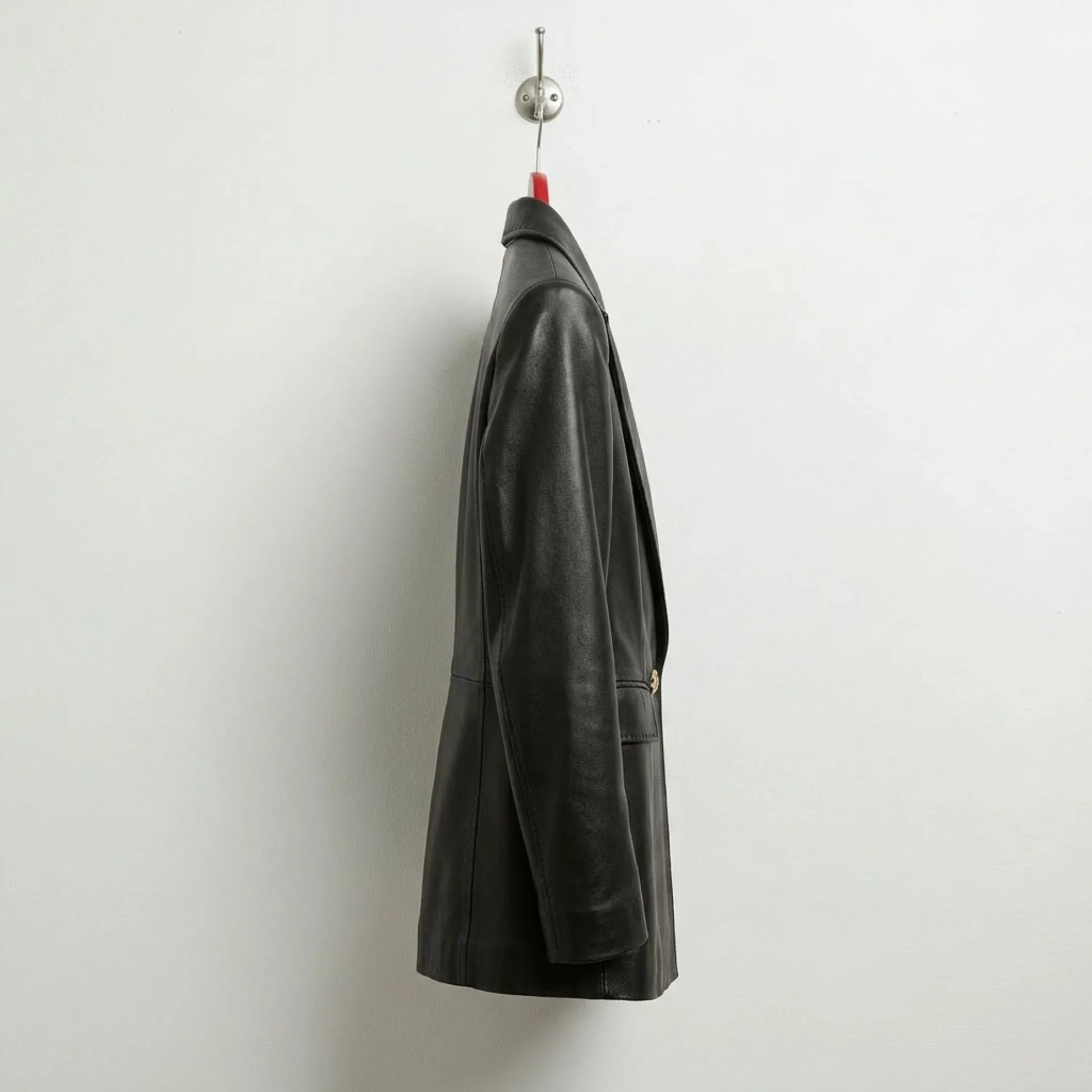 Side profile of women’s black leather blazer showing longline fit
