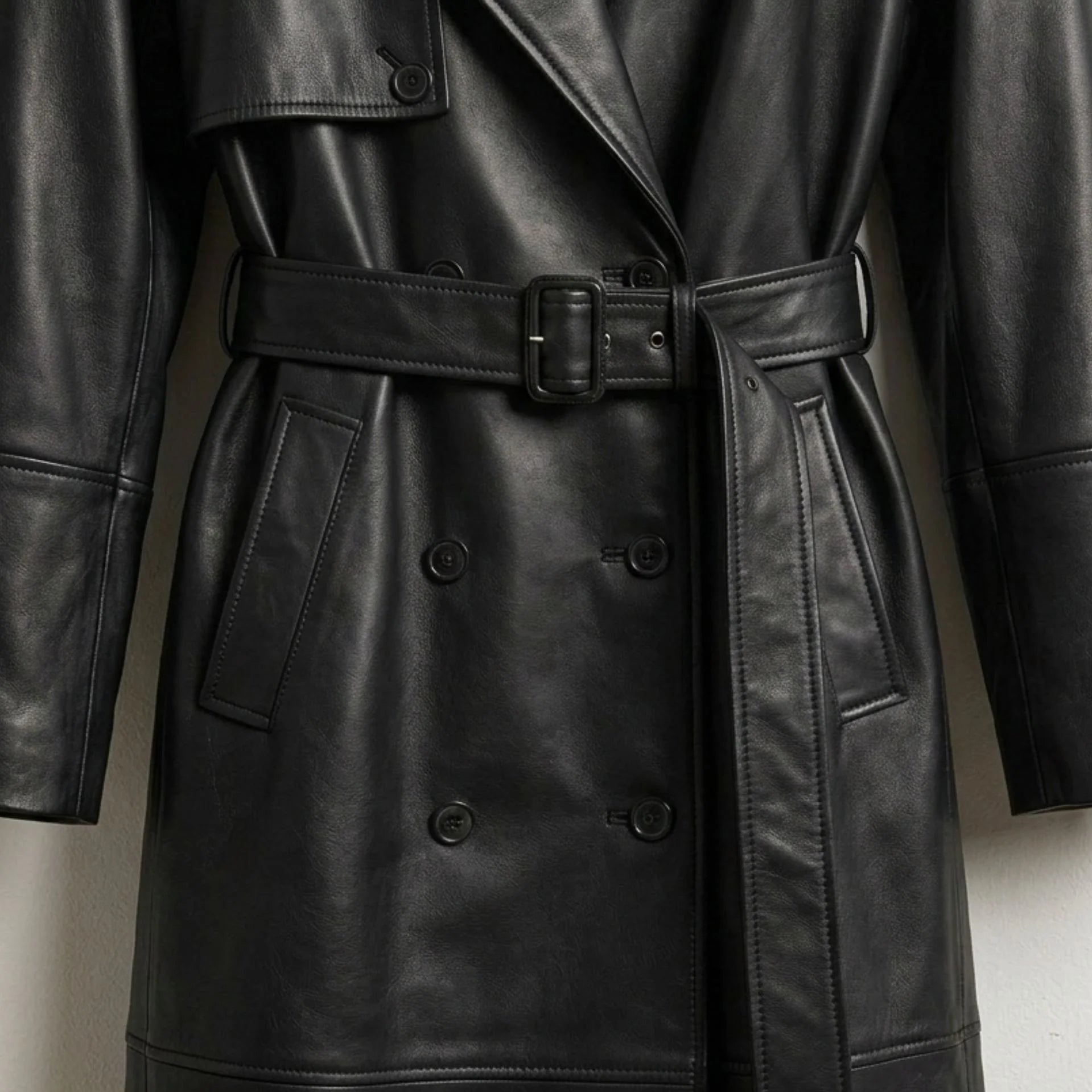 Belted waist and double breasted buttons on long black leather coat for women