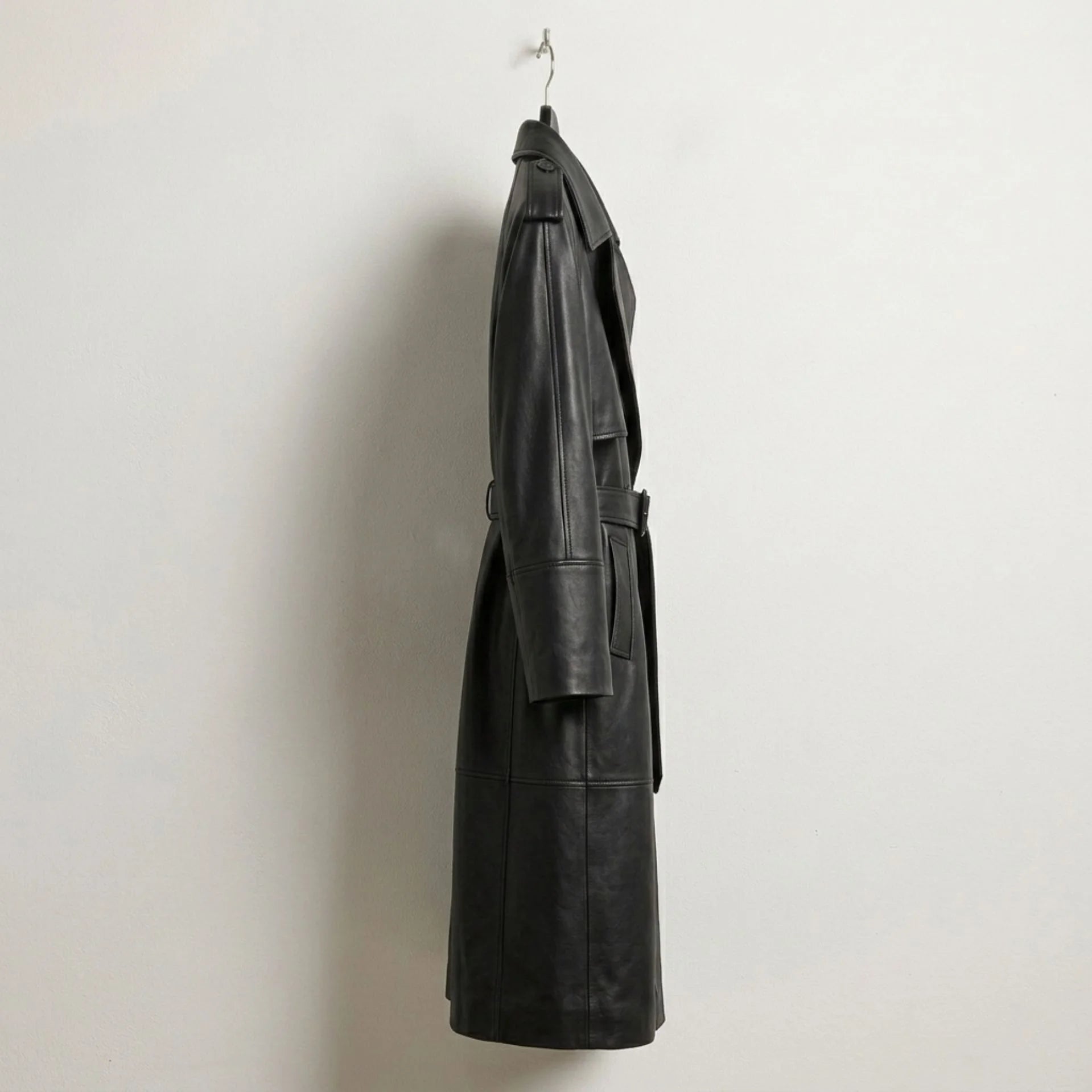 Side profile of long double breasted black leather trench coat