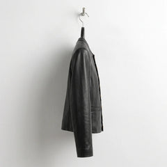 Side profile of women’s black scallop edge leather blazer