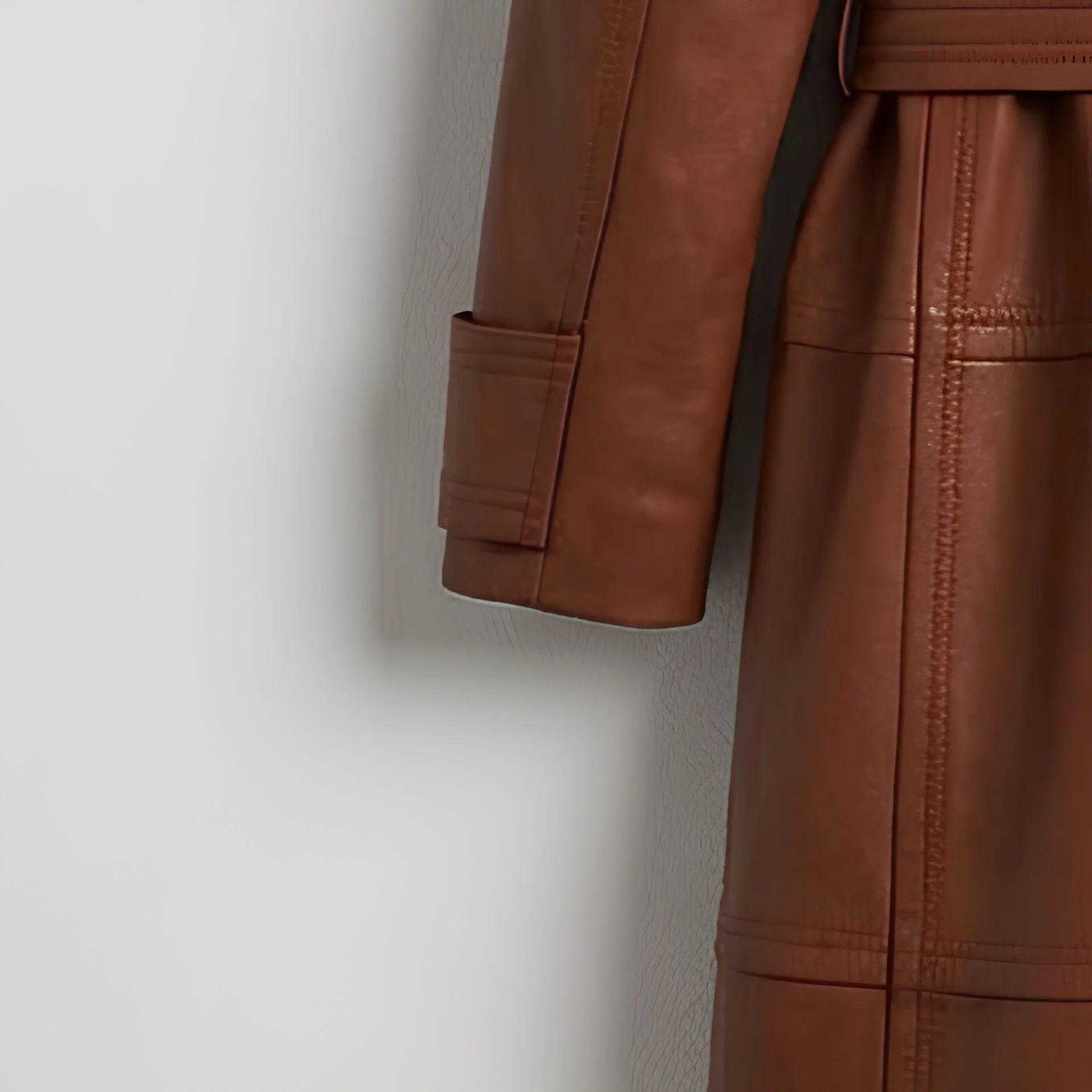 Sleeve cuff and stitching detail on women’s brown leather trench coat