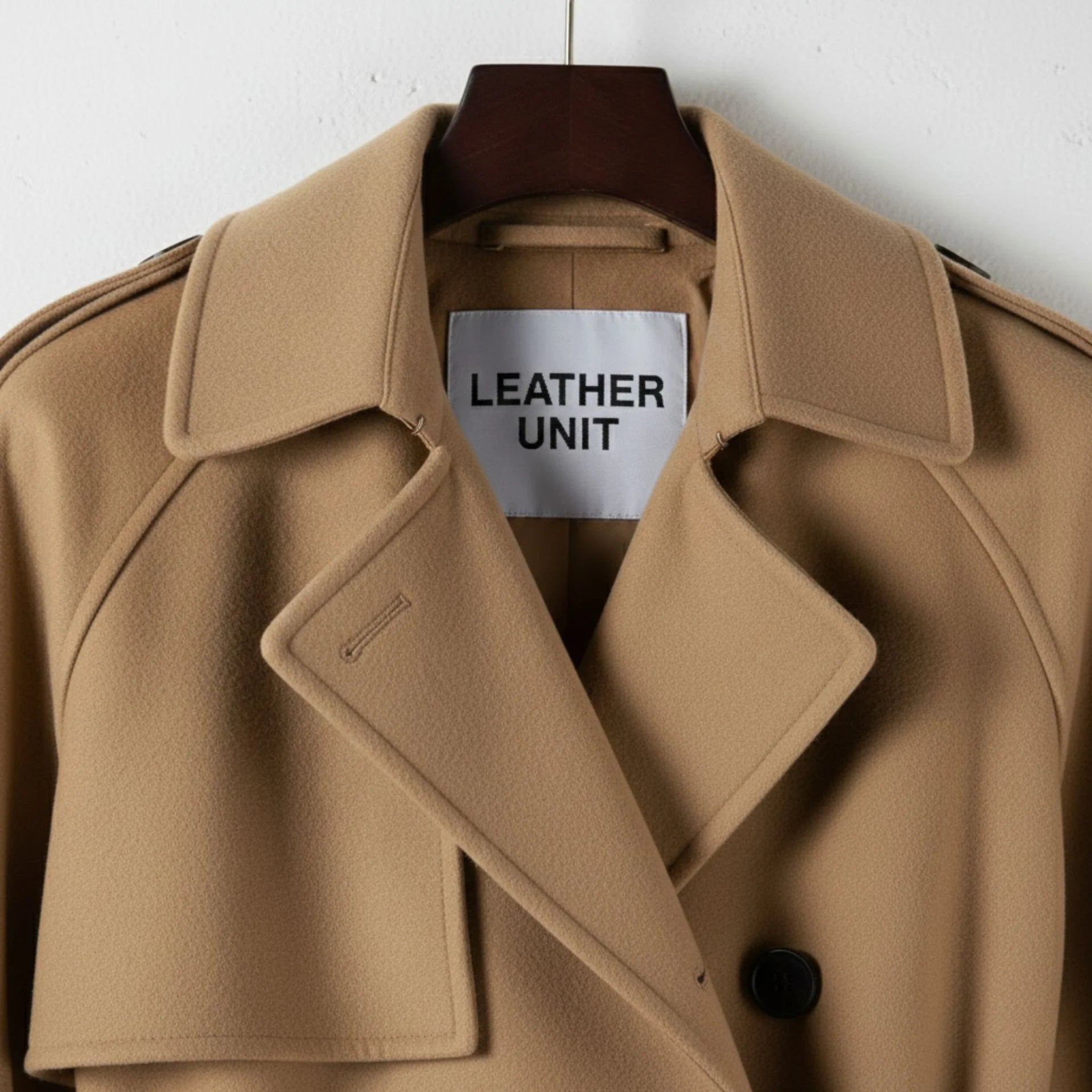 Close up of lapel collar and Leather Unit label on beige wool coat