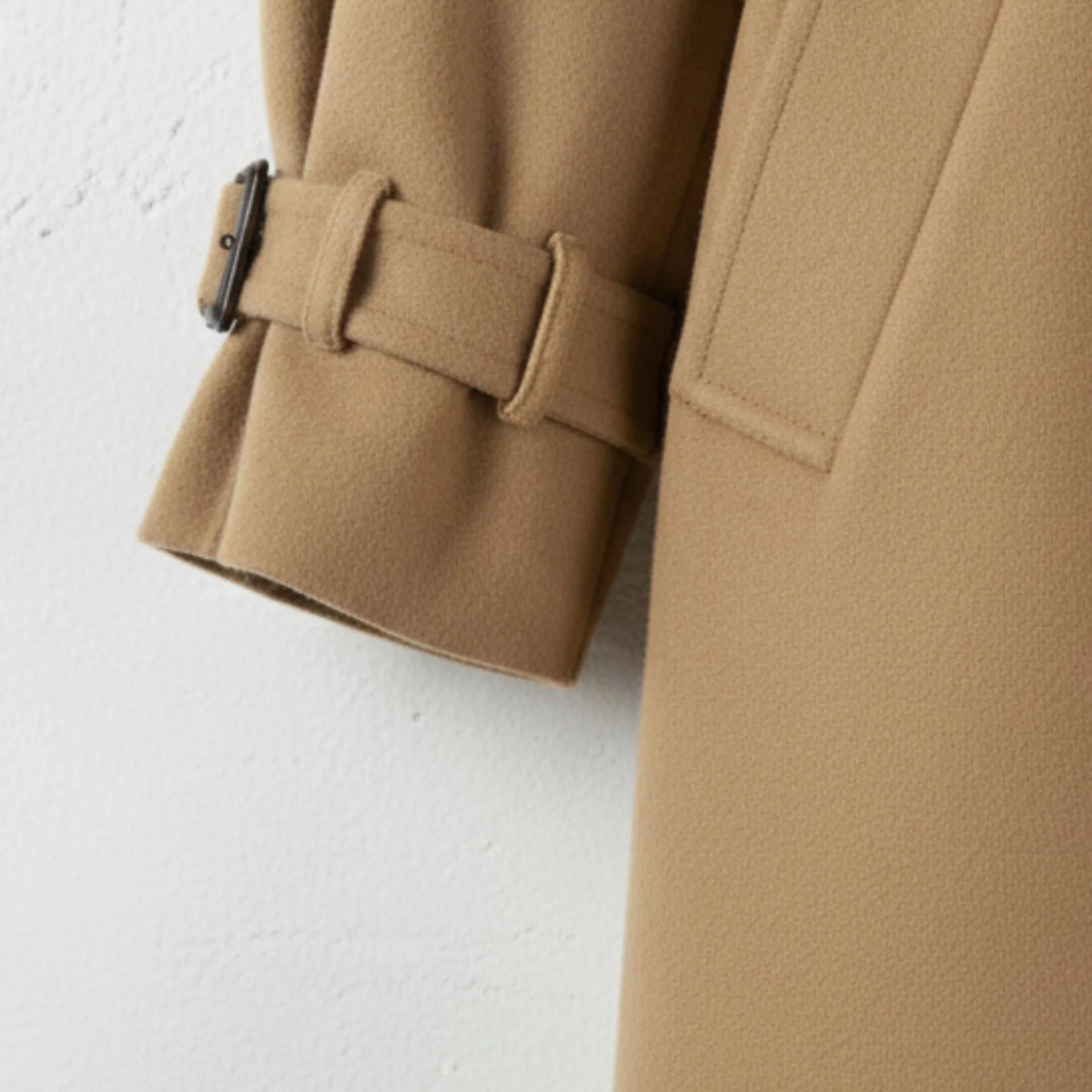 Cuff strap and buckle detail on women’s camel wool trench coat