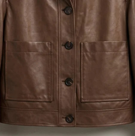 Front patch pocket and button closure detail on women’s dark brown leather jacket