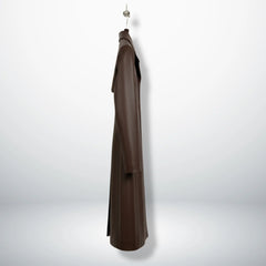 Side profile of women’s long brown leather overcoat showing straight fit