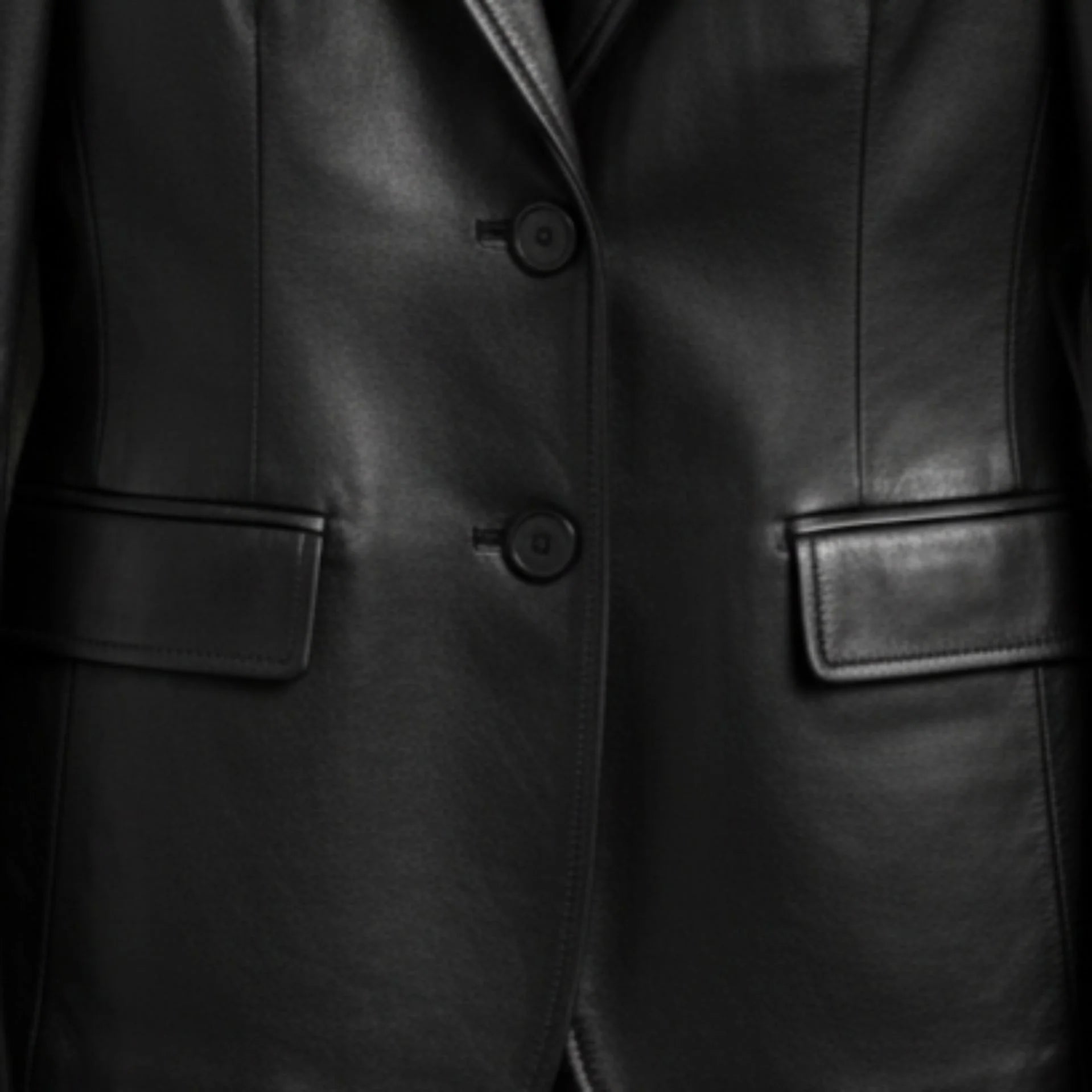 Two button front and flap pockets on women’s black leather blazer