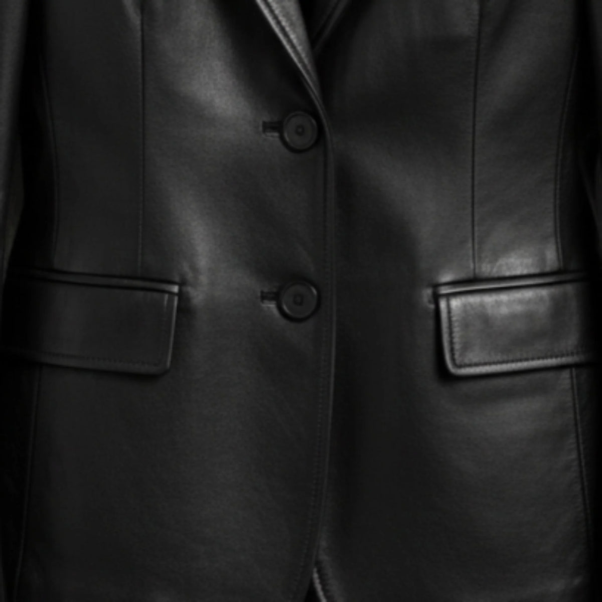 Two button front and flap pockets on women’s black leather blazer