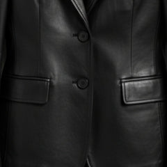 Two button front and flap pockets on women’s black leather blazer