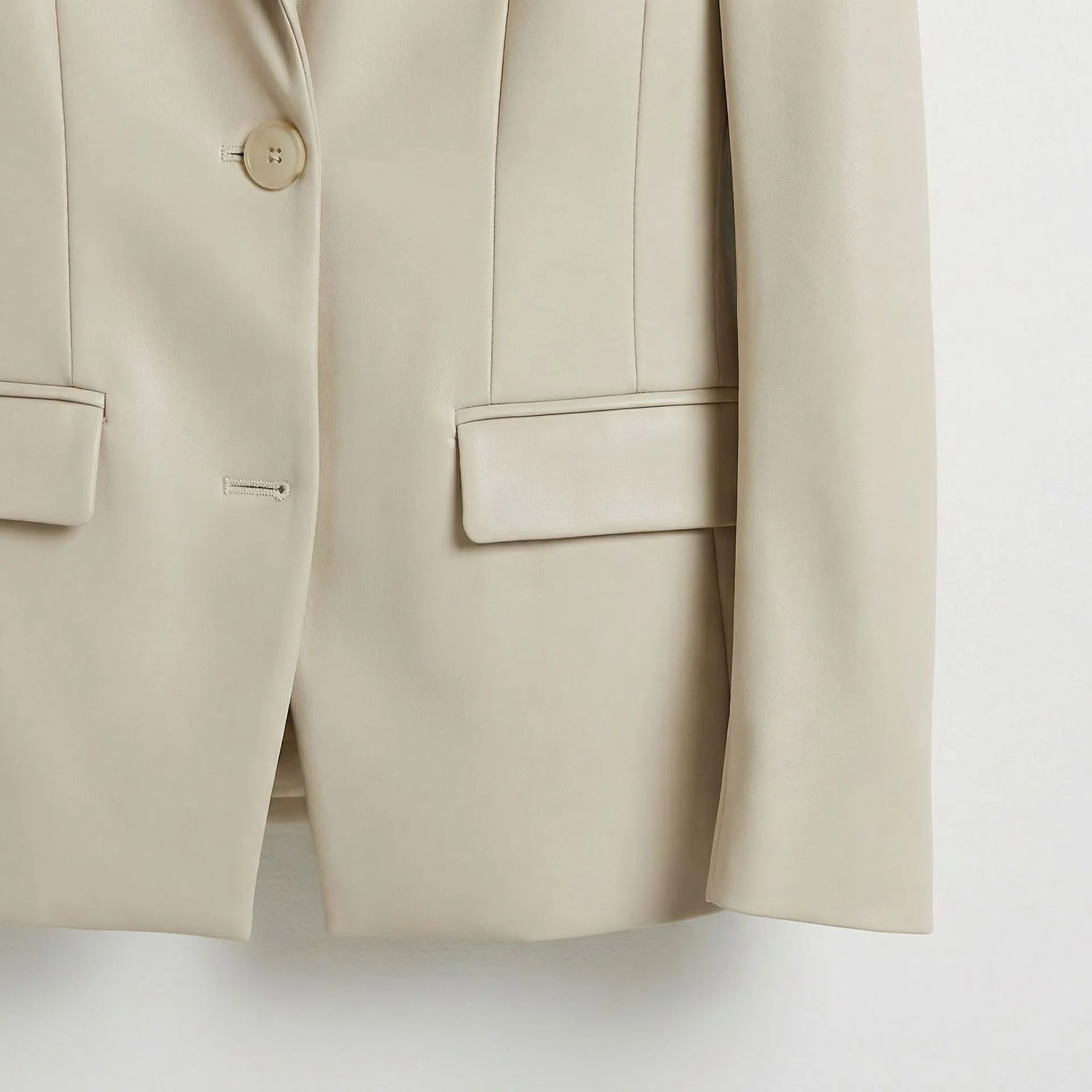 Single button front and flap pockets on women’s white leather blazer