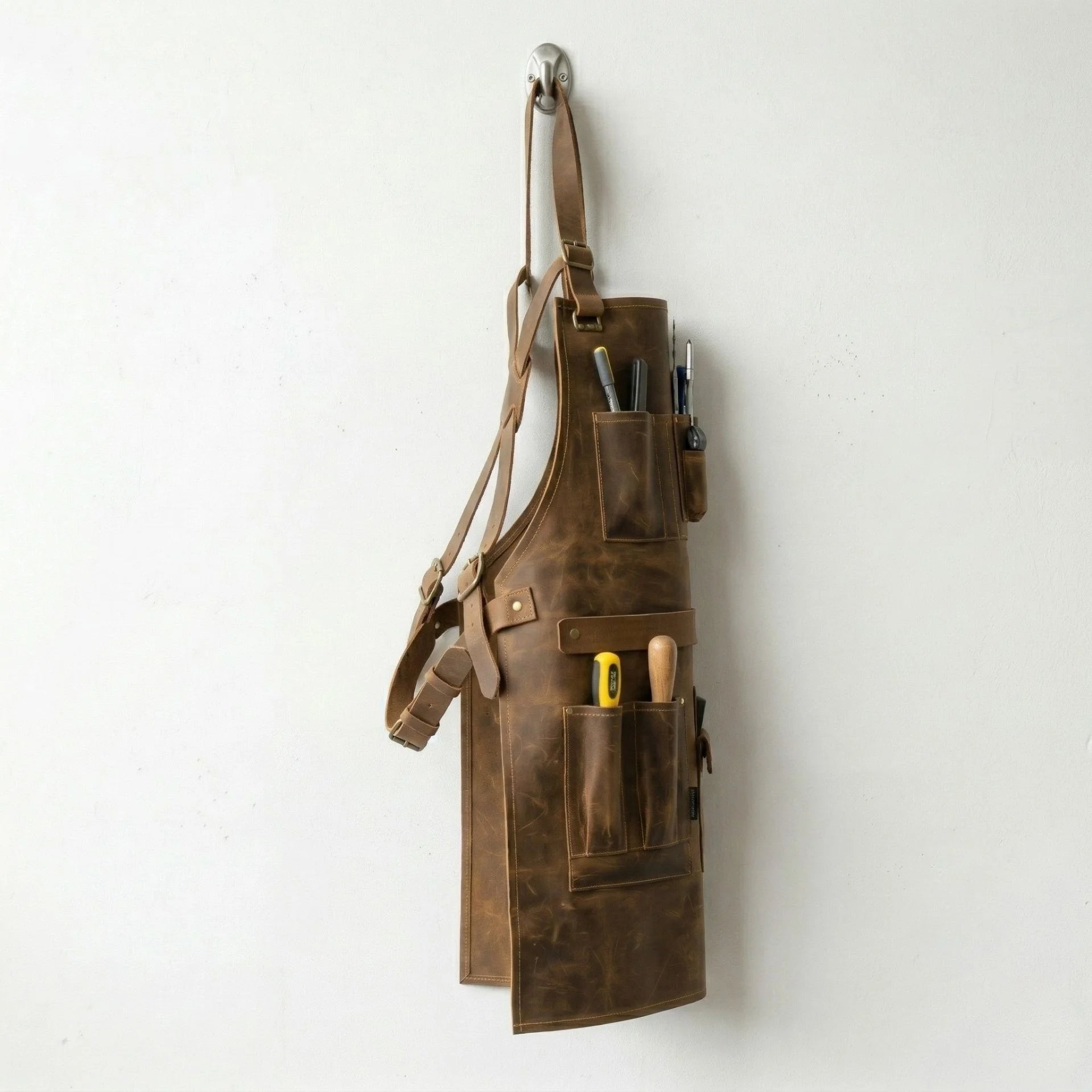 Side profile of brown cowhide woodworking apron loaded with tools