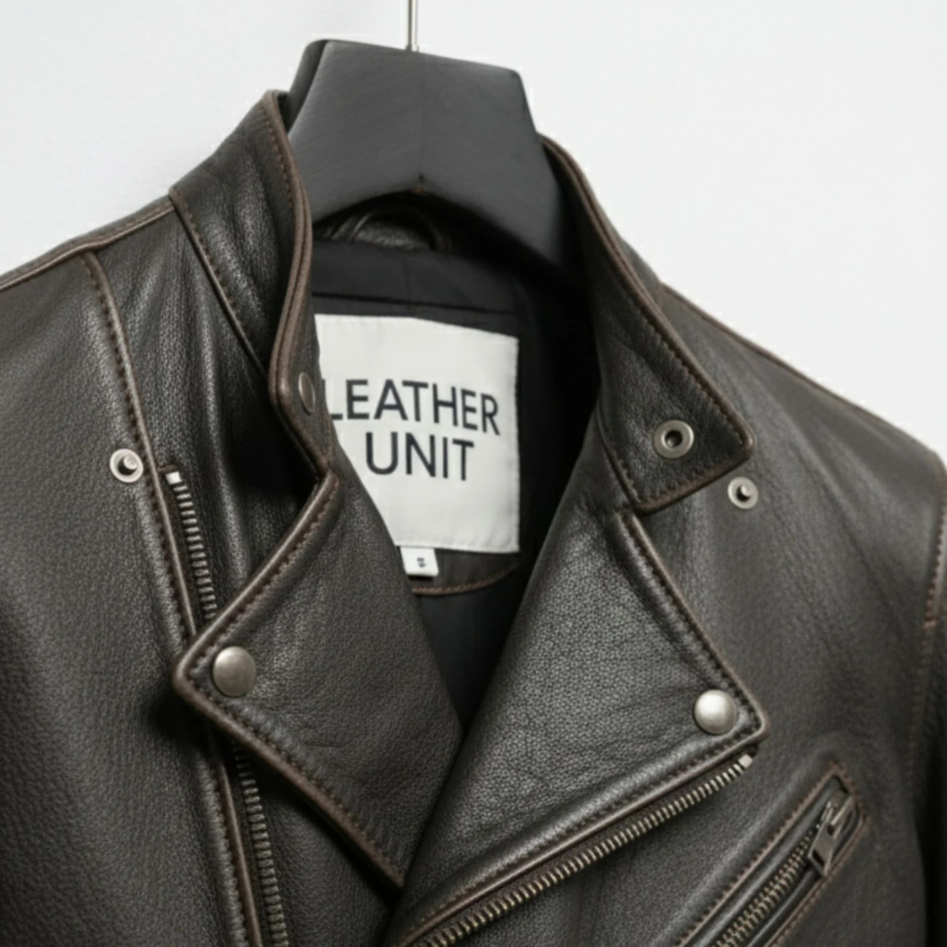 close up of lapel collar and snaps on men's asymmetrical leather biker jacket.