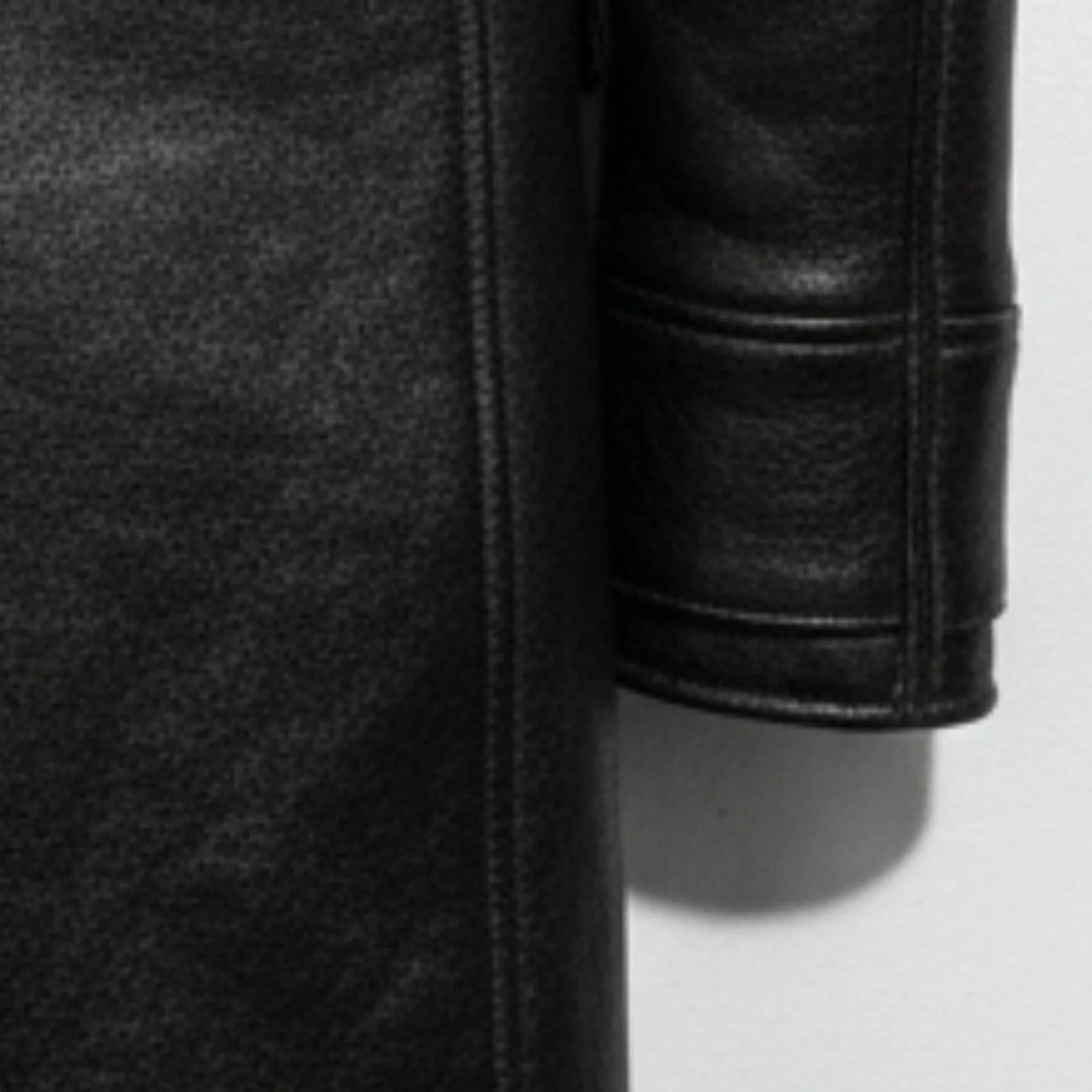 Detail of sleeve and grainy black leather texture on Bane style coat.