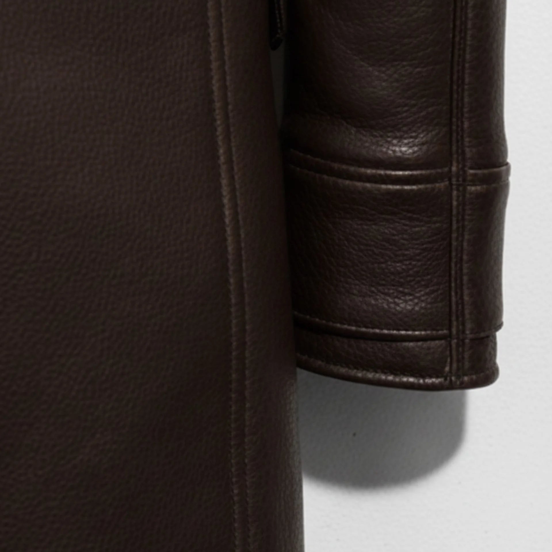 Detail of sleeve and grainy dark brown leather texture on Bane style coat.