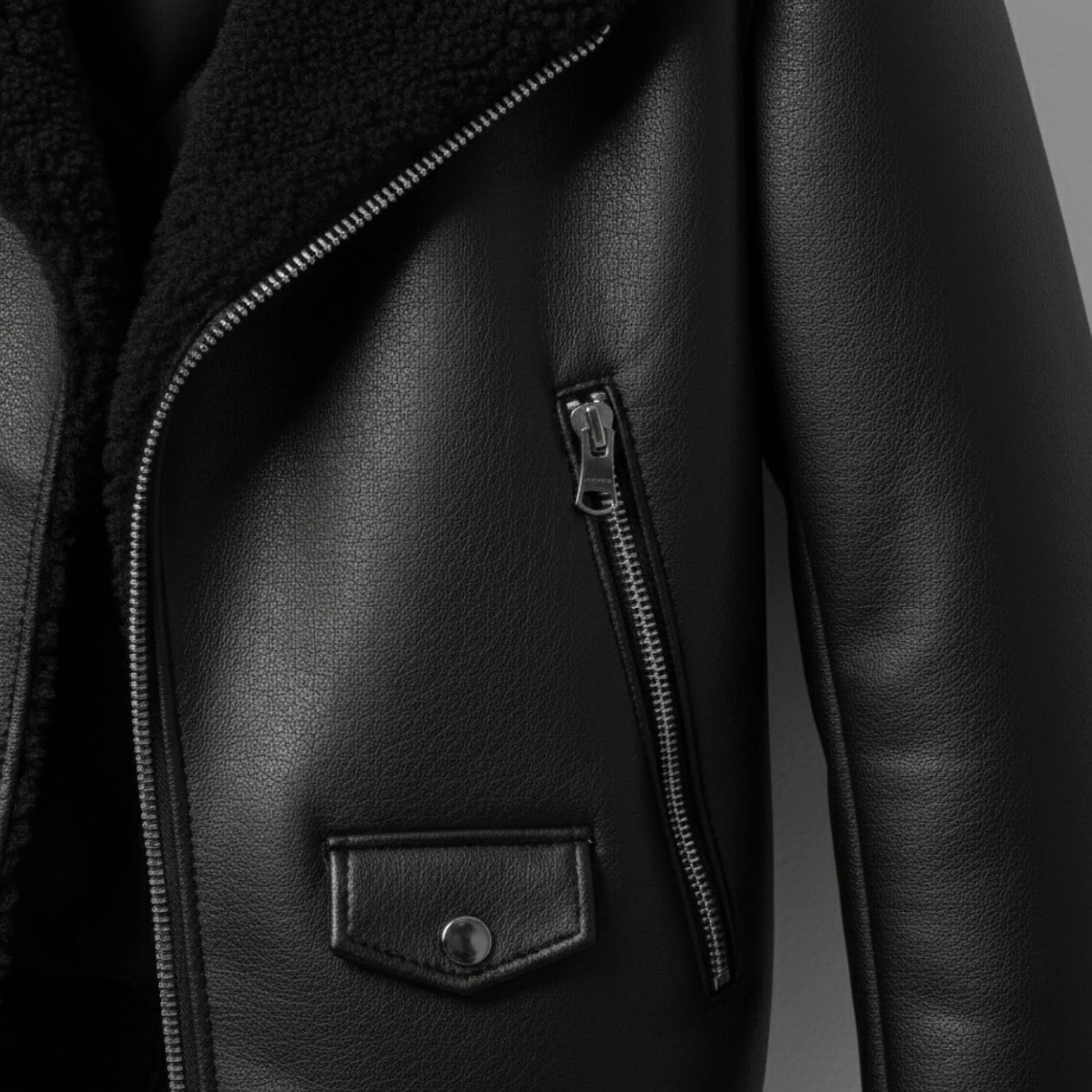 close up zipper pocket and flap pocket on mens black shearling leather jacket.