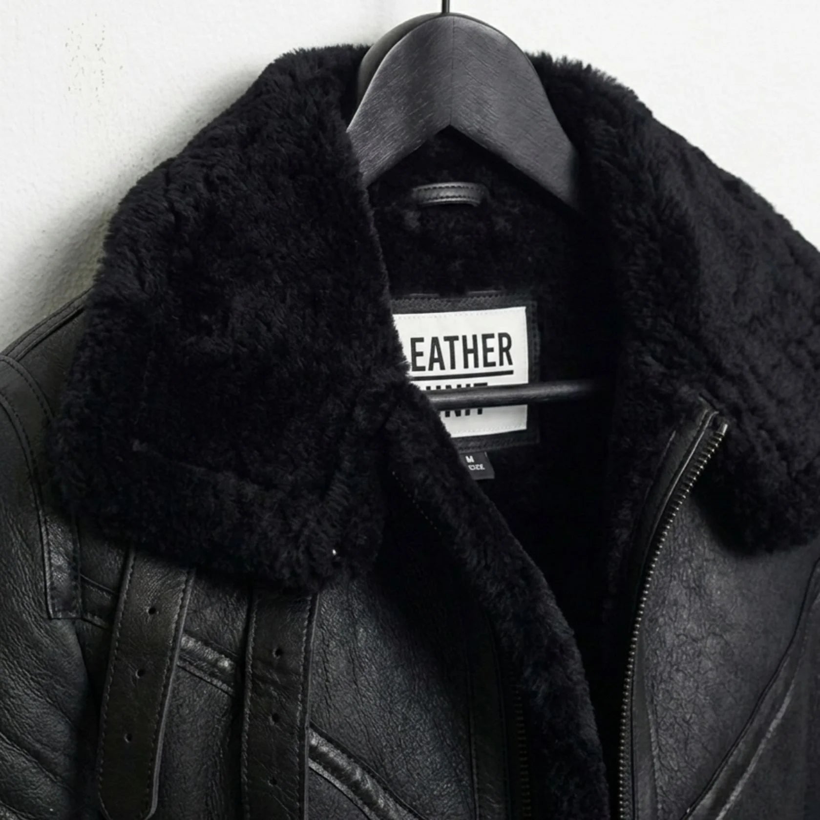 close up black shearling collar and label on mens b3 leather jacket.