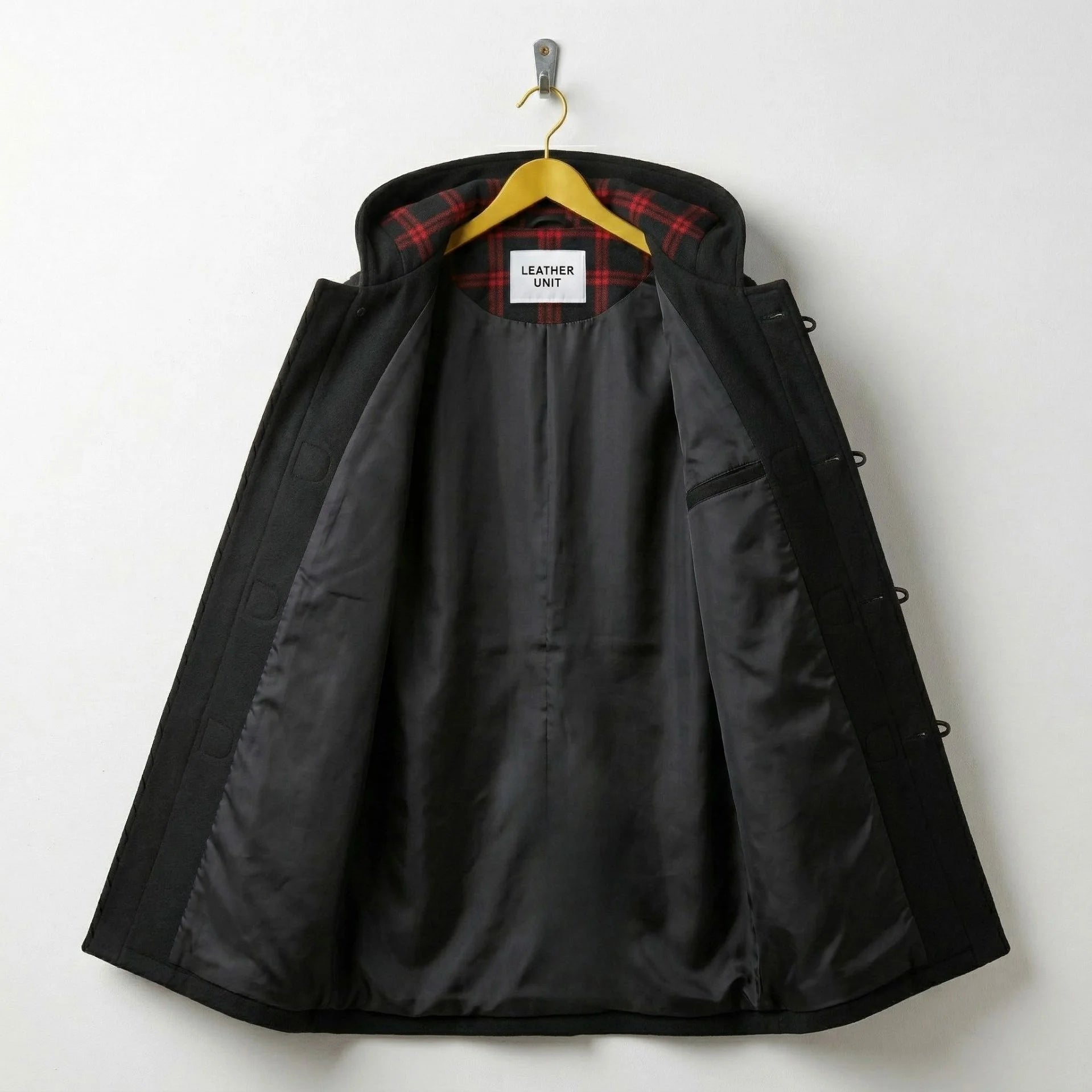 Interior of men's black duffle coat showing smooth lining and inner pocket.
