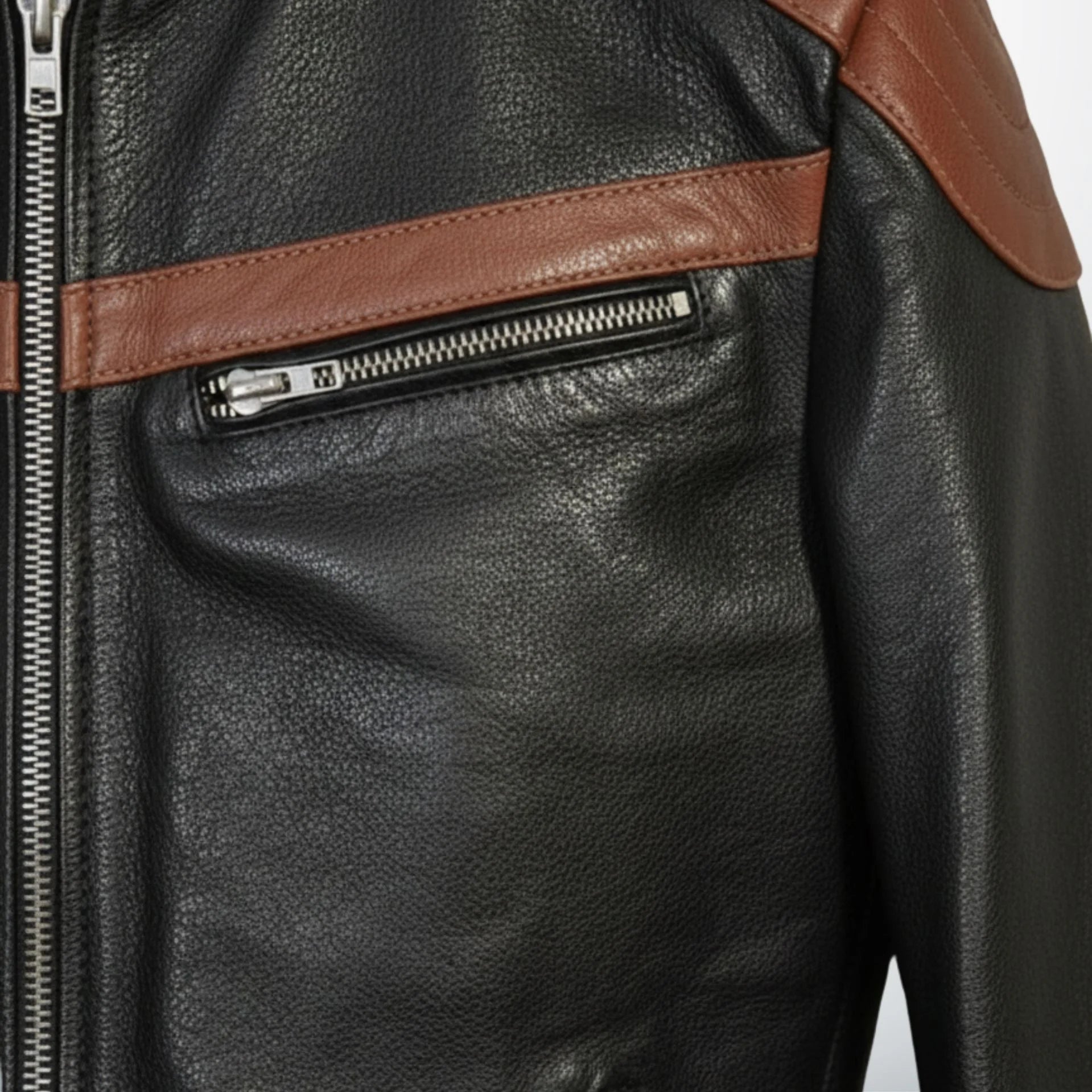 detail of chest zipper pocket and brown stripe on men's black leather biker jacket.