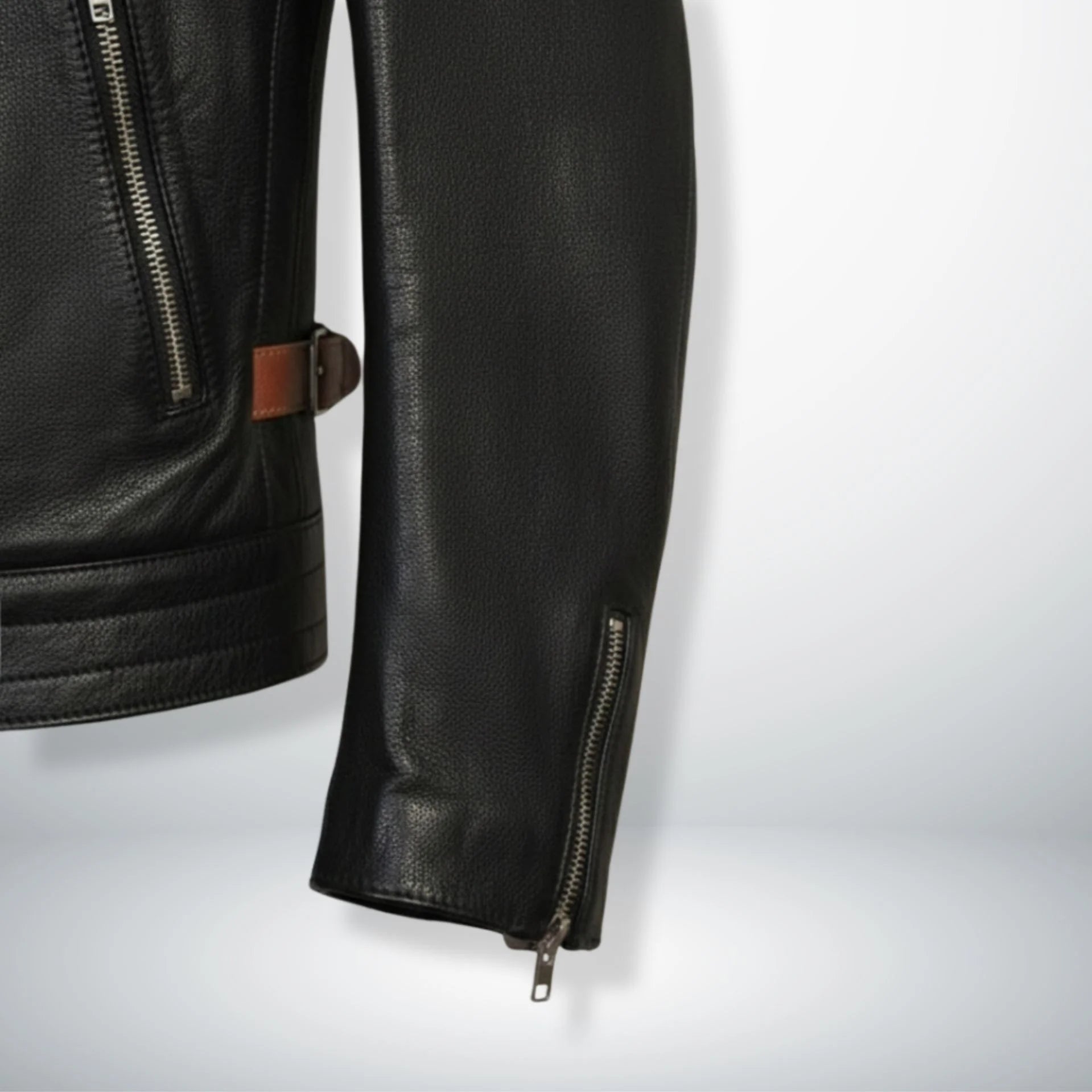 sleeve and cuff zipper detail on men's black leather jacket with brown side straps.
