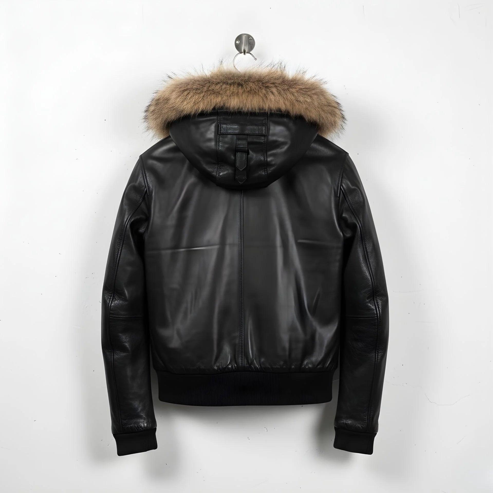 back view of men's black leather hooded bomber jacket with fur trim.