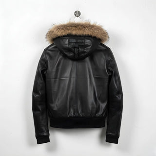 back view of men's black leather hooded bomber jacket with fur trim.