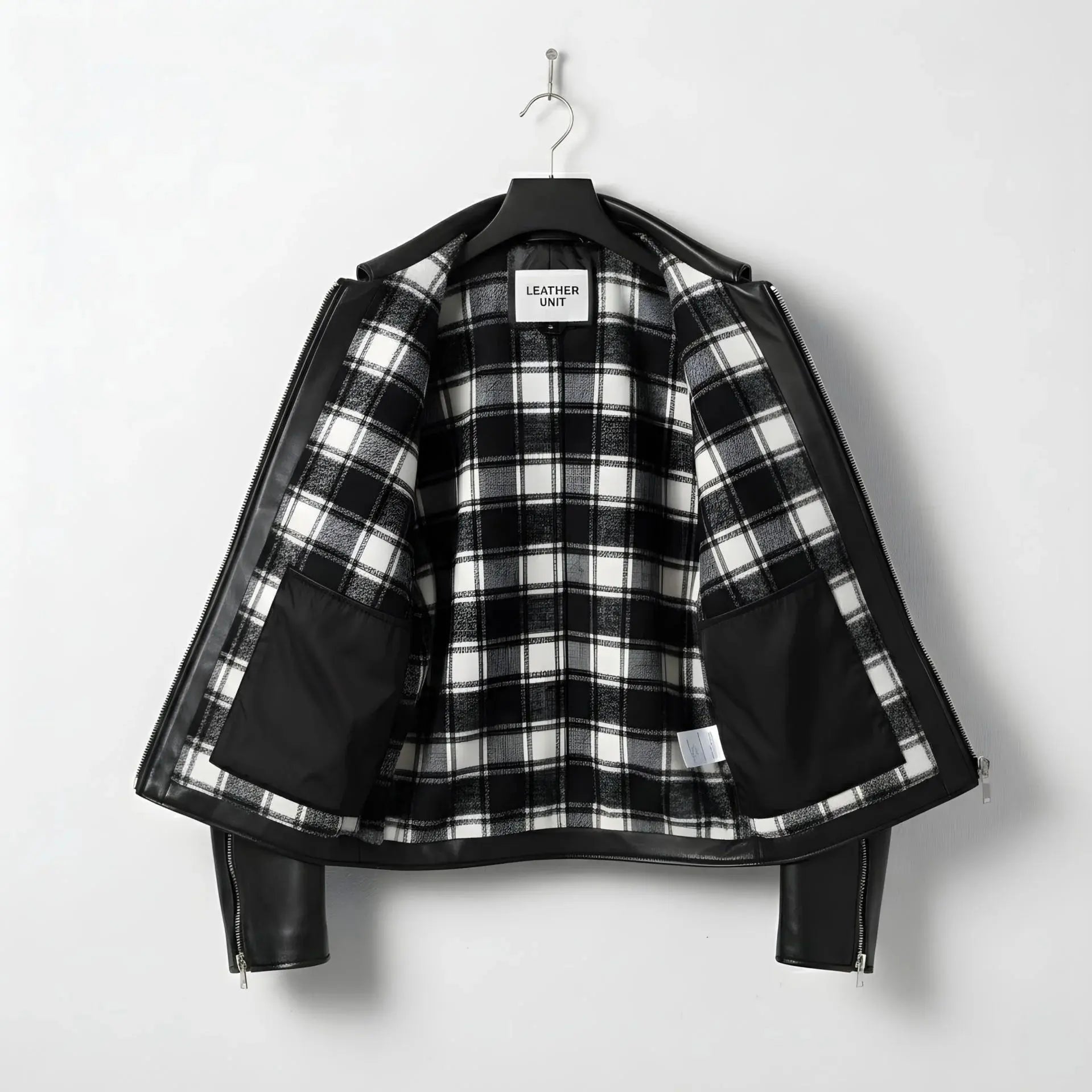 interior of men's black leather jacket showing black and white plaid lining.