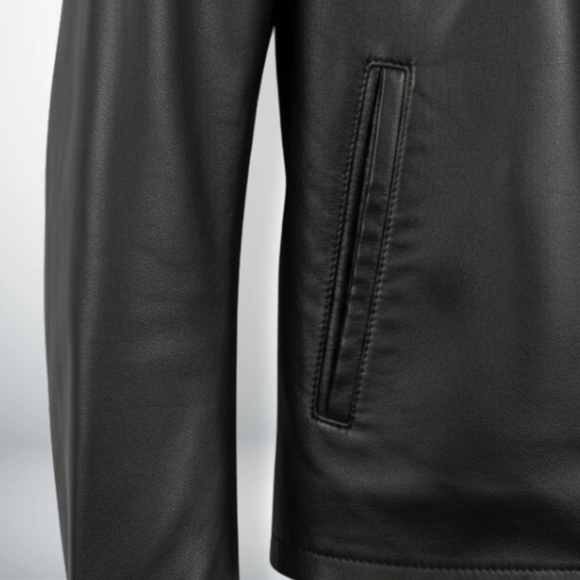 detail of front welt pocket on men's black leather jacket.