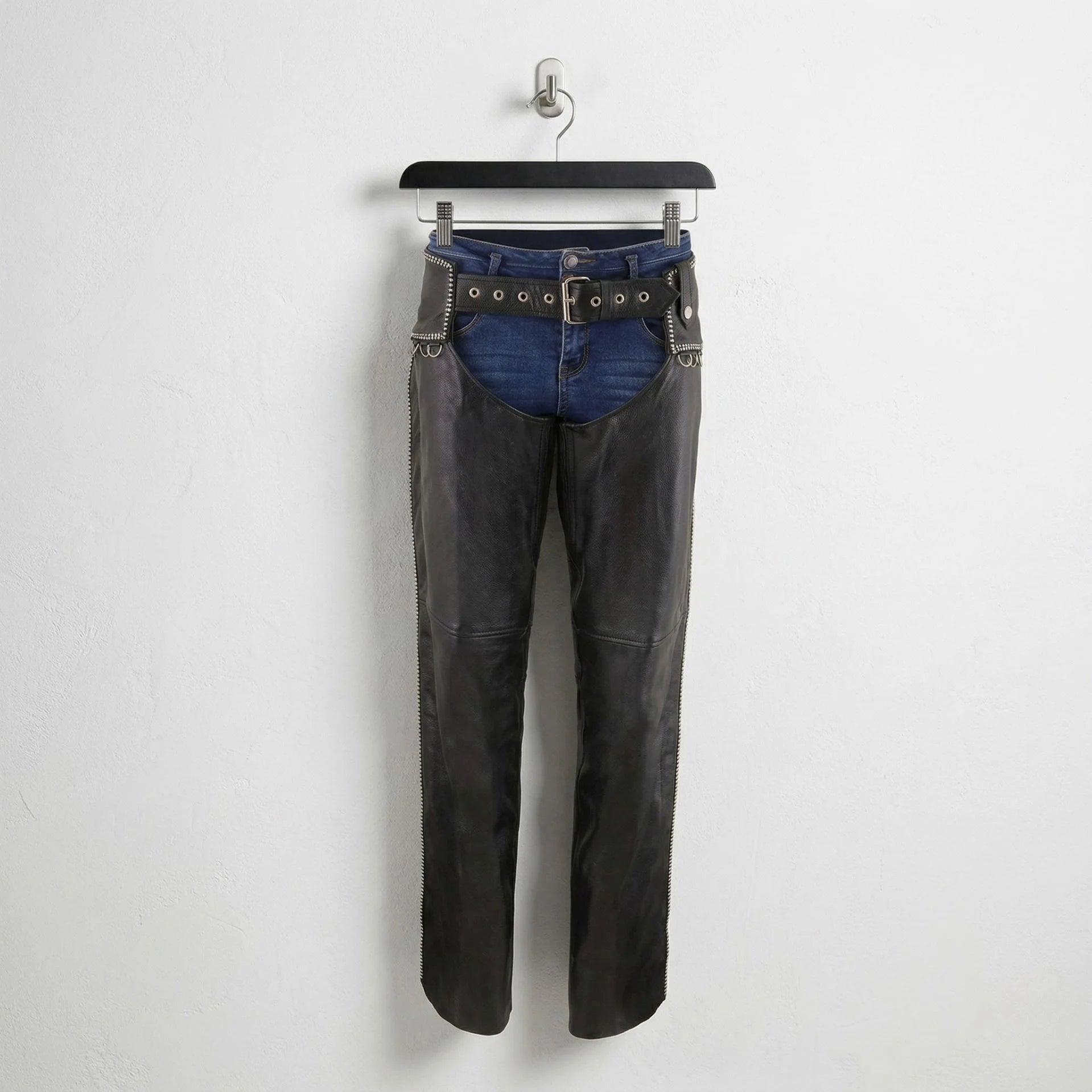 Front view of men's black leather motorcycle chaps with studded belt worn over blue jeans